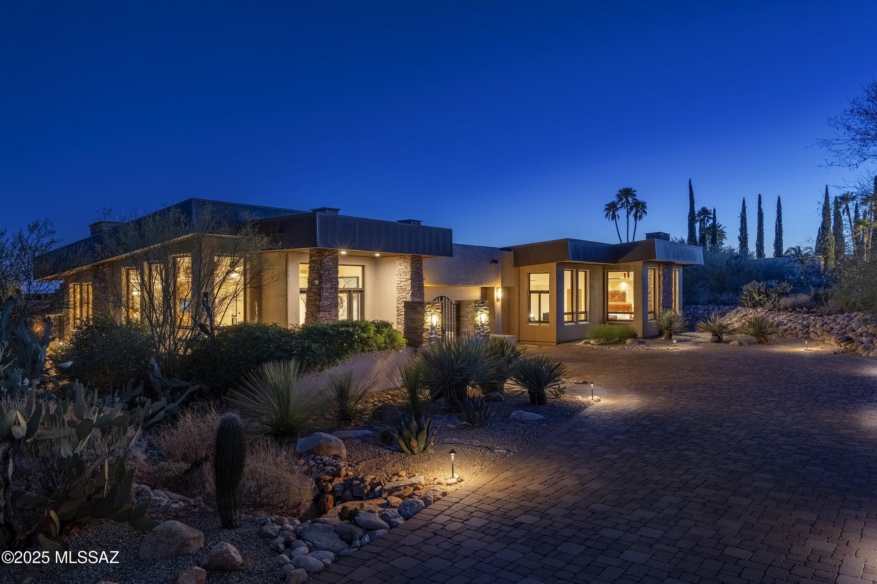 Located behind the exclusive gates of Pima Canyon, one of Tucson's most sought-after communities. This exquisite contemporary residence is thoughtfully composed and perfectly executed, offering a relaxed sophistication that speaks to those with a discerning eye for quality and an appreciation for natural beauty. From the moment one arrives, the architecture makes a quiet, yet confident statement. The entry foyer, with its soaring ceilings and sense of volume, introduces the home's contemporary yet timeless aesthetic. Clean lines, organic materials, and an effortless indoor-outdoor connection set the tone for what unfolds: a residence that lives with the ease and elegance of a private retreat. The expansive living room is bathed in natural light, where glass walls capture sweeping, uninterrupted views of the Catalina Mountains and the surrounding desert. Interiors are warm and thoughtfully curated, offering spaces that feel as suited to large-scale entertaining as they are to intimate evenings at home. Designed for both performance and beauty, the chef's kitchen features a substantial center island, natural stone countertops, bespoke cabinetry, professional series appliances and generous storage. Every element, from the layout to the finishes, has been considered for both function and visual aesthetic.

The primary suite is a world of its own, private and restorative. Framed by north facing picture windows, the room is filled with soft natural light and surrounded by views of lush native landscaping. The ensuite bath echoes calming tones and an elegant sense of restraint. A bright, versatile secondary suite, perfect as a guest room, sitting area, or office is conveniently located just off the primary. Two additional ensuite guest bedrooms are tucked into the south wing of the residence, each with direct access to the home's outdoor living spaces. 

Here, a covered veranda invites relaxed afternoons, whilst the resort-style pool and elevated spa provide a tranquil escape, perfectly placed to maximize sun, privacy, and the surrounding views. The exterior spaces are as intentional as the interiors, with multiple lounging and dining areas creating a natural flow for entertaining or quiet reflection. Every outdoor moment is elevated by the property's natural topography and graceful design, offering the ultimate in desert luxury living.  Combining architectural design with effortless livability, this residence is a rare offering, just minutes from Tucson's finest dining, shopping, and hiking, yet worlds away from the ordinary.

This home has seen an impressive series of upgrades during current ownership designed to enhance both comfort and functionality. Notable improvements include the replacement of new LENNOX HVAC units, ensuring efficient climate control throughout. The roof was recoated, while the pool and spa were fully resurfaced with new miniPebble coating and tiles, alongside upgraded Pentair IntelliCenter equipment, all with a 10-year transferable warranty. The kitchen was enhanced with a new Sub-Zero refrigerator and wine cooler, with cabinetry modified to accommodate these additions. The interior was repainted, and energy-efficient motorized shades were installed throughout. Outdoor enhancements include the repair of flagstone joints and the addition of new stone pathways, and realignment of riprap along the property's driveway.