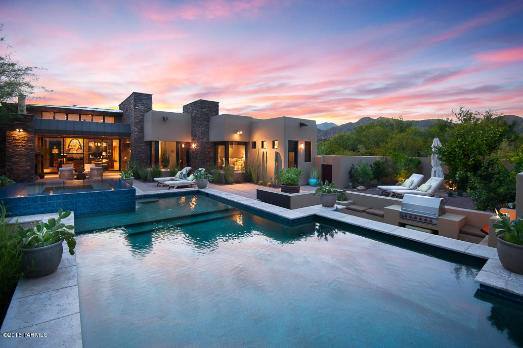 Stunning contemporary home located in prestigious guard-gated Stone Canyon. This property is a must see with premium amenities throughout creating the perfect home for relaxation and entertainment. Generously set back from the 12th fairway, extremely private. Entering the home through a large glass pivoting front door opening to the foyer with tranquil views of the Tortolita Mountains and charming outdoor covered patio with fireplace. Gourmet granite island kitchen with Wolf appliances, Subzero refrigerator, Asko dishwashers, microwave drawer, warming drawer, ice maker, climate controlled wine storage, large butlers pantry and quality cabinetry. Living room/great room w/ built in cabinetry, bar sink, fireplace and floor to ceiling retractable doors that open to covered patio with full outdoor kitchen overlooking resort like pool, spa waterfall and fabulous views of the Catalina Mountains.  Additional sitting area by the pool for grilling and relaxing.  Additional features:  Two fully appointed guest suites with baths, media room, office master bedroom with sitting area w/ serene views, luxury bath, large walk-in closet. Security, lighting and media controlled by Crestron.