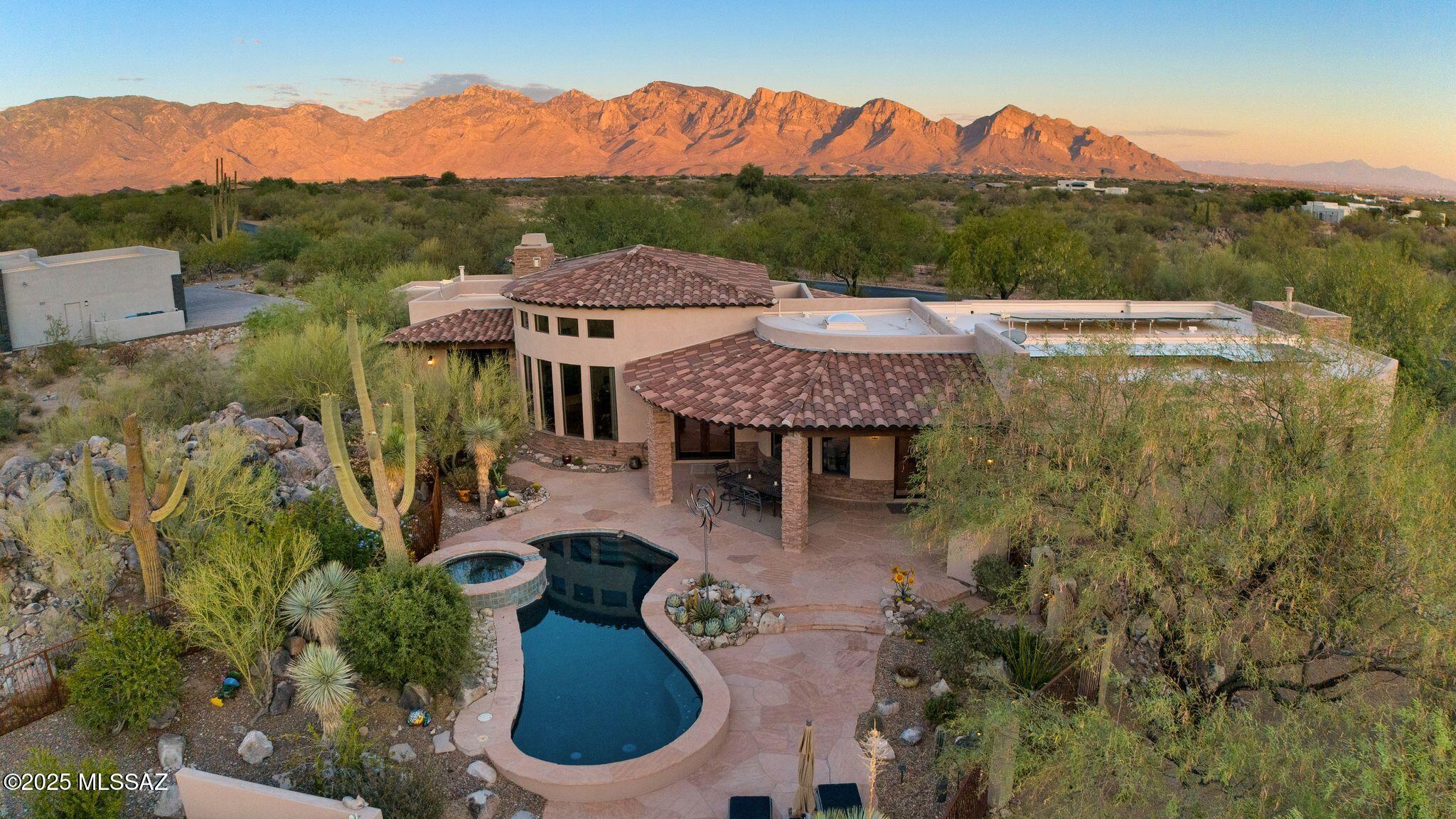 Experience luxury desert living in this beautiful 3-bedroom, 4-bath Tuscan estate in the exclusive Stone Canyon community. With over 4,200 sq. ft. of living space and a dedicated office, this home sits on a private 1-acre lot featuring owned solar, smart-home technology, and breathtaking mountain and sunset views. Enjoy high ceilings, natural stone floors, and large windows that fill the home with light. The gourmet kitchen opens to a spacious living and dining area with a wet bar and gas fireplace, perfect for entertaining. The primary suite offers dual vanities, a jetted tub, walk-in shower, and custom closet. Two additional en-suite bedrooms provide comfort and privacy for guests. Relax outdoors on the flagstone patio with an outdoor kitchen, pool and spa, and private putting green. This home blends timeless design, modern upgrades, and resort-style living all within one of Tucson's most sought-after communities.