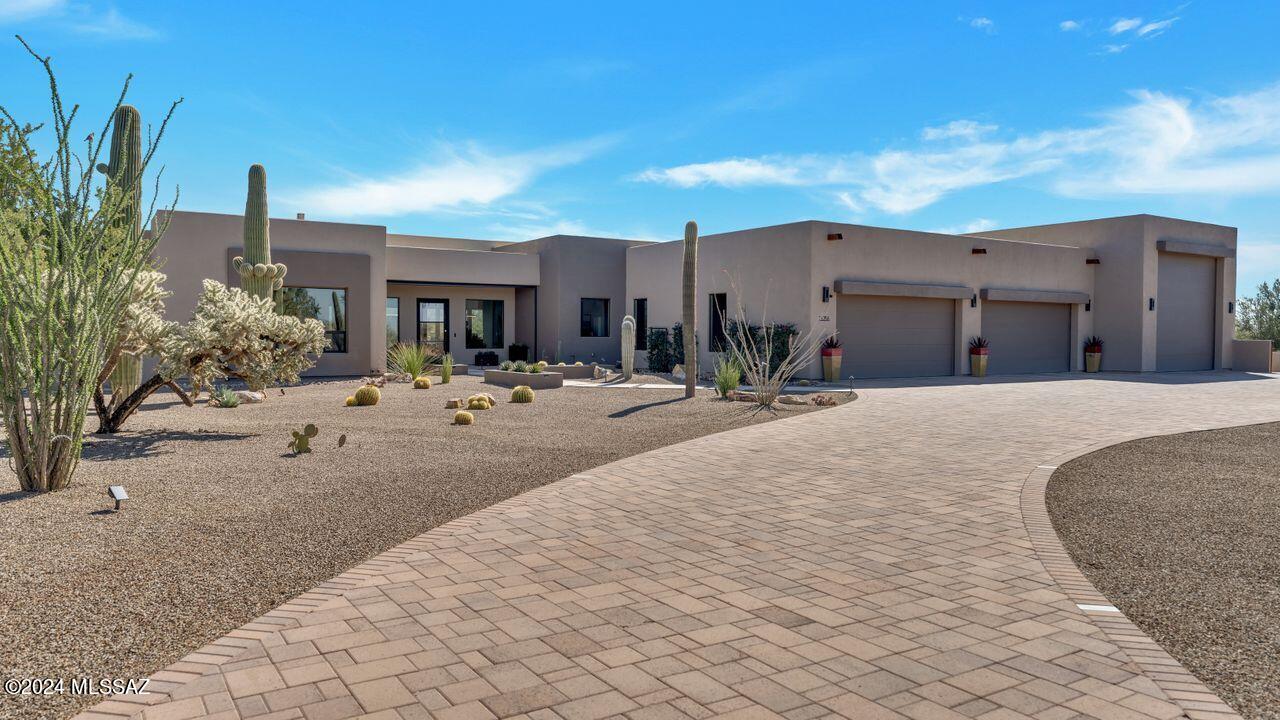 Unparalleled Catalina Mountain views from this contemporary custom home in gated Naranja Ranch Estates, paved, secluded enclave of just 10 homes in Oro Valley. Situated on over 3.3 acres, this home is a true private paradise! Not to mention the spectacular 4 car garage plus RV garage, (Can be 7 car garage). 1/2 bath, TV, 220 elec. mini split AC, dump station & side yard for addl. toys. The split plan home boasts open great room, dining, kitchen w/huge stunning island, CAFE appl, walk-in pantry. Office & primary BDRM, 1/2 BA on North side, South side offers 2 guest BDRM each w/their own baths, laundry RM.  Salt-water Lagoon pool, spa, fire feature overlooking open desert & mountains. Covered patio areas, w/rolling shutters can create special AZ RM. blt in BBQ. Come view this one of a kind