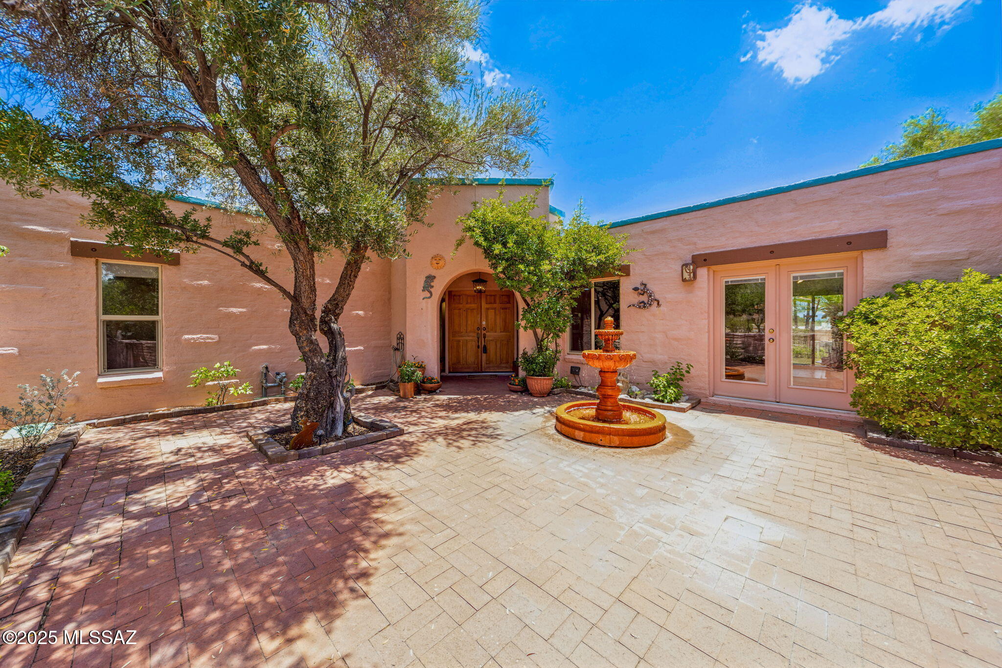 Discover the charm of this classic burnt adobe home, quietly nestled on a cul-de-sac in the desirable Sabino Vista Knolls. Set on a spacious .40-ac lot, it offers exceptional privacy, lush desert landscaping, & Catalina Mountain views. A gated brick-paver courtyard with a peaceful water feature welcomes you into a home filled with pride of ownership. Natural light flows through French and sliding glass doors, illuminating a bright, layout with 4 bedrooms & updated guest and half bath. The kitchen is a true highlight, featuring alder soft-close cabinetry, granite counters, stainless appliances, and a sunny breakfast nook with a lovely courtyard view. Backyard is your private oasis with a deep covered patio overlooking lush landscaping  tranquil water features & a sparkling Pebble tec pool! Updated pool equipment too! Easy-care turf and mature trees offer shade and serenity, making it the perfect spot to relax or entertain year-round. Located in a friendly, walk able neighborhood ideal for outdoor living, you'll enjoy peaceful strolls, mountain views from the front courtyard, and the warm sense of community that defines Tucson living. Just minutes from Sabino Canyon, Whole Foods, BASIS North, and Fruchthendler Elementary, this home blends quiet retreat with unbeatable convenience. Additional peace of mind comes with major updates already completed: roof re-coated April 2025 (w/ 2-year Diamondback Roofing warranty), termite warranty through April 2026 (Rigo Pest), and HVAC replacement in 2023 with new variable speed thermostat installed 2025. Main sewer line under home lined by Bio Remedies July 2025 with transferable warranty. Come see why 7810 E Oakwood Place is more than a house, it's a home! Call your favorite Realtor and make this home yours today!