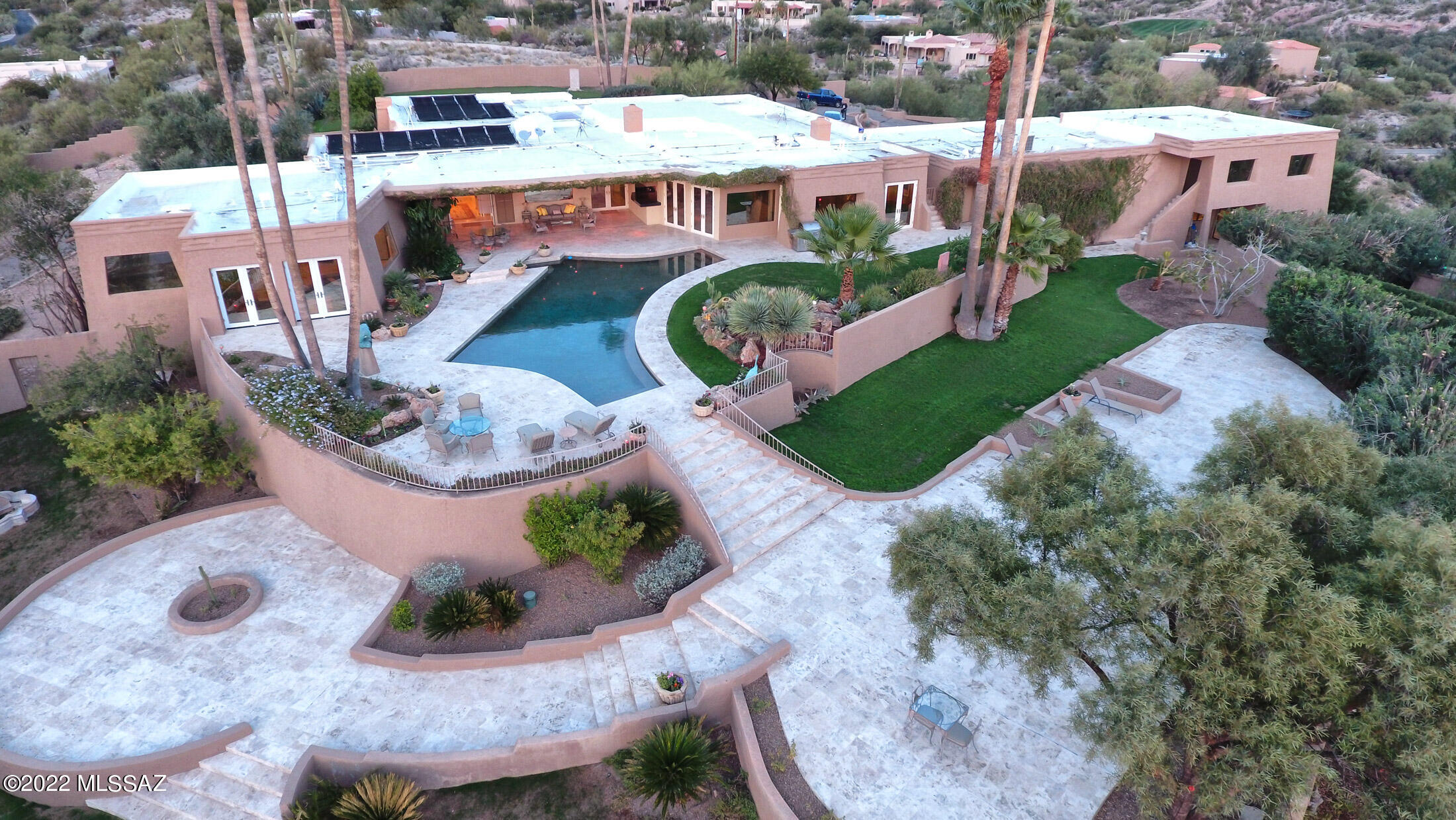 One's home has always been thought of as a place of refuge, and this is exemplified by Casa De Maya, a very private gated quintessential Tucson Foothills estate home on over 4 acres with dramatic view portals and expansive gardens. Envisioned for both large-scale entertaining and intimate family life, this is a luxurious compound providing a gorgeous primary home of 4 bedrooms and nearly 7000 sq ft, and outbuildings providing an additional 3300+ sf allocated to guest quarters, offices, maids quarters and a gym. Interior spaces range from open and soaring to cozy and intimate, blurring the boundaries between interior and exterior spaces. The gated and walled impressive entry gate opens to a long private drive to the primary home. Upon entry, you are greeted by the impressive entry and central hall establishing the main connection point of the primary home, with elegant Travertine flooring that floats seamlessly throughout the space. The heart of the home is the elegantly recreated Chef's kitchen with gorgeous finishes throughout, including contemporary custom cabinetry complimented with granite counters and sleek nickel-finished door pulls, with high-end appliances including a wine refrigerator. An adjacent pantry, also with granite counters, provides substantial additional storage and work space. The connected breakfast room provides an interactive space as it looks out to magnificent views of the pool and rear gardens. A sophisticated formal living room is graced with a welcoming fireplace and room for a grand piano. A nearby powder room evokes a style found in the glorious older homes of Beverly Hills. Across the unifying central hall is a formal dining room accommodating a stunning large glass table that can stay with the home. This hall leads to a charming smaller library with another delightful fireplace, and out to the stunningly beautiful pool, grounds with multiple patios and terraces, and an exquisite outdoor bar. Large wall space accommodating substantial artwork is found throughout the spaces, creating a lush living environment. Quiet sitting areas are found around the property, with covered and open patios unwinding to provide multiple spots for entertaining and enjoyment of the outdoors and views. The owners suite is concealed in the West Wing of the property, boasting a spacious bedroom/sitting area with glass shelving perfect for an art collection or family photos and opening onto the rear terrace and pool. The sumptuously appointed bathroom includes a mirrored dressing area with generous closed closets, and continues into a private sitting area with a spa, access to the outdoor pool through a swim-out feature and a luxurious glass-walled steam room. Three other bedrooms, two with fabulous en-suite baths, and an office space, complete the primary home. This truly is a "Grand Dame" of the Tucson Foothills. The three-car garage is oversized and provides several separate storage areas.  An adjacent one Acre lot is also available, please enquire.
About the area: The Catalina Foothills is located north of the city downtown area, with easy access to cultural events, the U of AZ and outstanding medical facilties. This area is known for the beauty of the Sonoran Desert, incredible views, fine dining and shopping, excellent schools, world-class golf and tennis resorts and several country clubs.