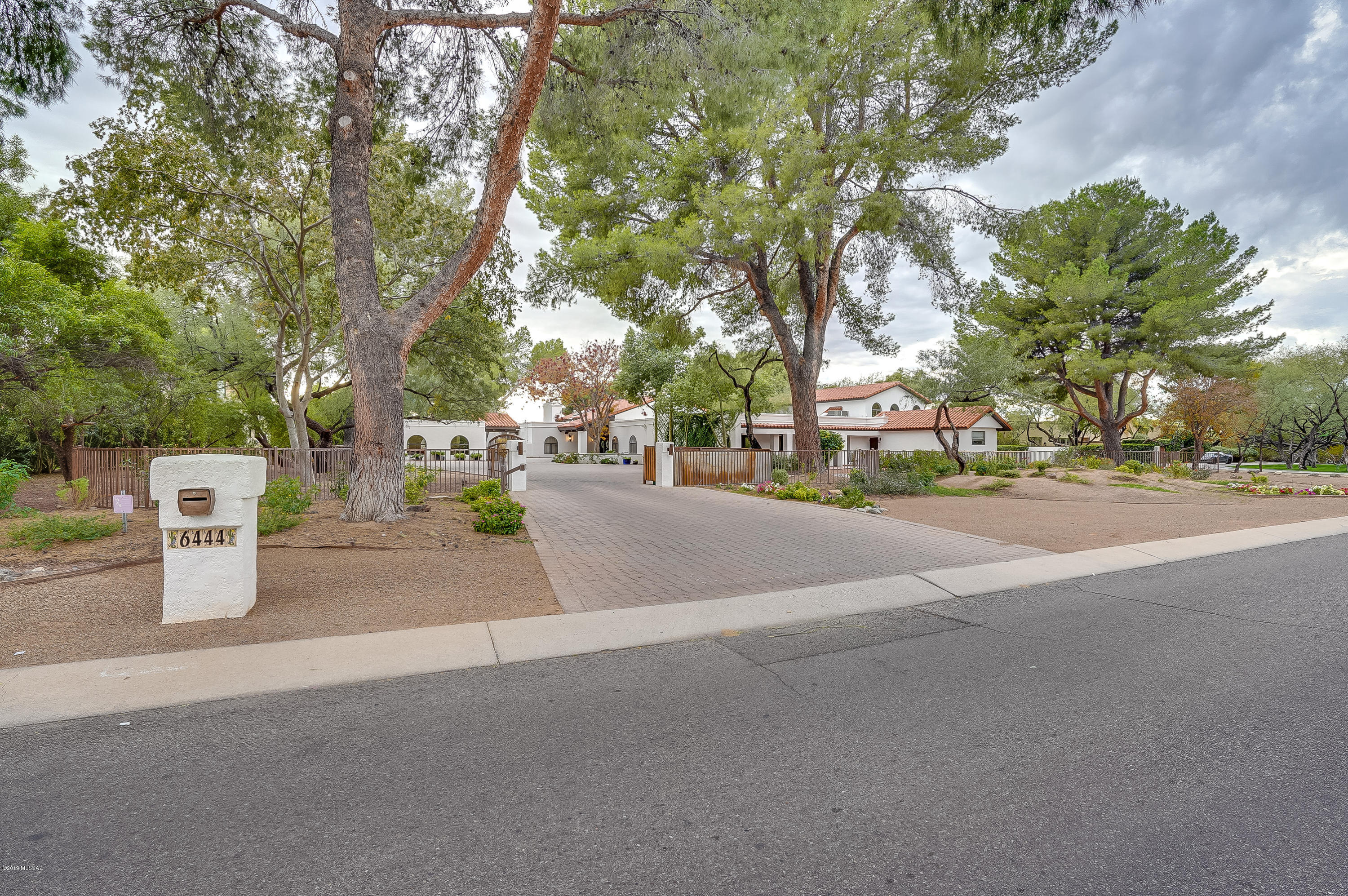 Spectacular estate sitting on 1.6 acres in the prestigious Tucson Country Club featuring resort style living! Breathtaking sunset views, lighted tennis and basketball courts, grand pool and spa, horse facilities, outdoor kitchen with fireplace, outdoor bathroom, 3 car garage, massive paved driveway, 1 bd/1 ba guest house, surrounded by mature trees and plenty of space for expansion or parking makes this home a rare find. The main house embraces a spacious and elegant floor plan, exposed ceiling beams, 4 large master bedrooms, a glorious master suite, several bonus rooms and spaces, an entertainer's delight kitchen, a classy wet bar, 4 gas fireplaces, and more. This home is ideal for entertaining and for enjoying Tucson's lifestyle at its finest all year long!