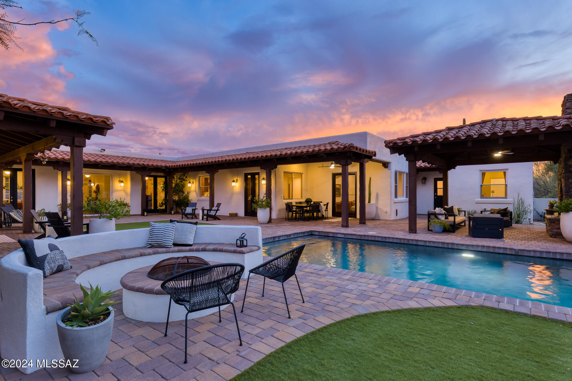 Range Price $1,995,000-$2,195,000Extensively renovated five-bedroom Spanish Revival with a guest house near the top of Campbell Avenue. This prime foothills homesite delivers up-close, unobstructed city, mountain, & sunset views.  The curated selection of materials combined with quality craftsmanship distinguishes this property from others. A circular driveway leads to the charming red brick walkway to the entry courtyard & covered patio. Upon entry, exceptional Catalina Mountain views are revealed through the large picture window that displays the U-shaped design of the home that wraps around three sides of the yard to create a sheltered area for enjoying the indoor/outdoor Arizona lifestyle. The entry hallway is flanked by an exquisite formal living room anchored by a wood-burning fireplace adorned in Talavera tiles, and the formal dining room with city views.  French Oak wood floors balance the white walls with warmth & style. Every detail of this home's impeccable interior comes together perfectly to deliver a refined visual experience rooted in subtle sophistication. The current owners took on the painstaking task of transforming the original, closed-off kitchen & family room into an open & functional space to enjoy with friends & family. No expense was spared in the new kitchen with new tile flooring,  custom cabinetry, Calacatta Gold Silestone countertops, a massive center island with a breakfast bar, a ceiling-mounted range hood, new fixtures, & all-new high-end stainless steel appliances. A lovely breakfast nook provides additional informal dining. The new kitchen is open to the family room with a stunning fireplace covered in Cle tile. Windows & French doors stream in natural light & provide access to the outdoor spaces.The courtyard-style back yard has extensive covered patios lined with brick pavers & a large ramada with a fireplace. The one-bedroom/one-bathroom guest house, outfitted with a darling kitchen area, can be used by visiting guests, as a home office, gym or a pool house for the kids. The home's west wing is complete with two bedrooms, one with a fully renovated en-suite bathroom with a shower & a show-stopping powder room with Tabarka tiles from floor to ceiling. The spacious, completely updated laundry room is conveniently located off of the entry to the oversized 3-car garage. On the east wing of the home, there is an en-suite guest bedroom with a walk-in closet & the magnificent owner's suite. The spa-inspired
owner's suite bathroom has been dramatically transformed into a  space to relax & recharge with new 24 x24 tile floors, dual vanities with custom cabinetry, backsplash & countertops, and a large, new shower with a separate steam room & a soaking tub. Uncommonly large his & hers closets. The owner's bedroom has a distinctive fireplace with a custom mesquite mantle & doors that go out to the back yard. The fully landscaped, low-care backyard has artificial turf, a pool with a water feature, a fire pit with built-in seating and a covered ramada with a wood burning fireplace. The north/south exposure makes the backyard a lovely place to be. Get to the University of Arizona in less than 10 minutes from this convenient foothills location. Walk to La Encantada Mall & Manzanita Elementary School. Just minutes from La Paloma Country Club & so much more.