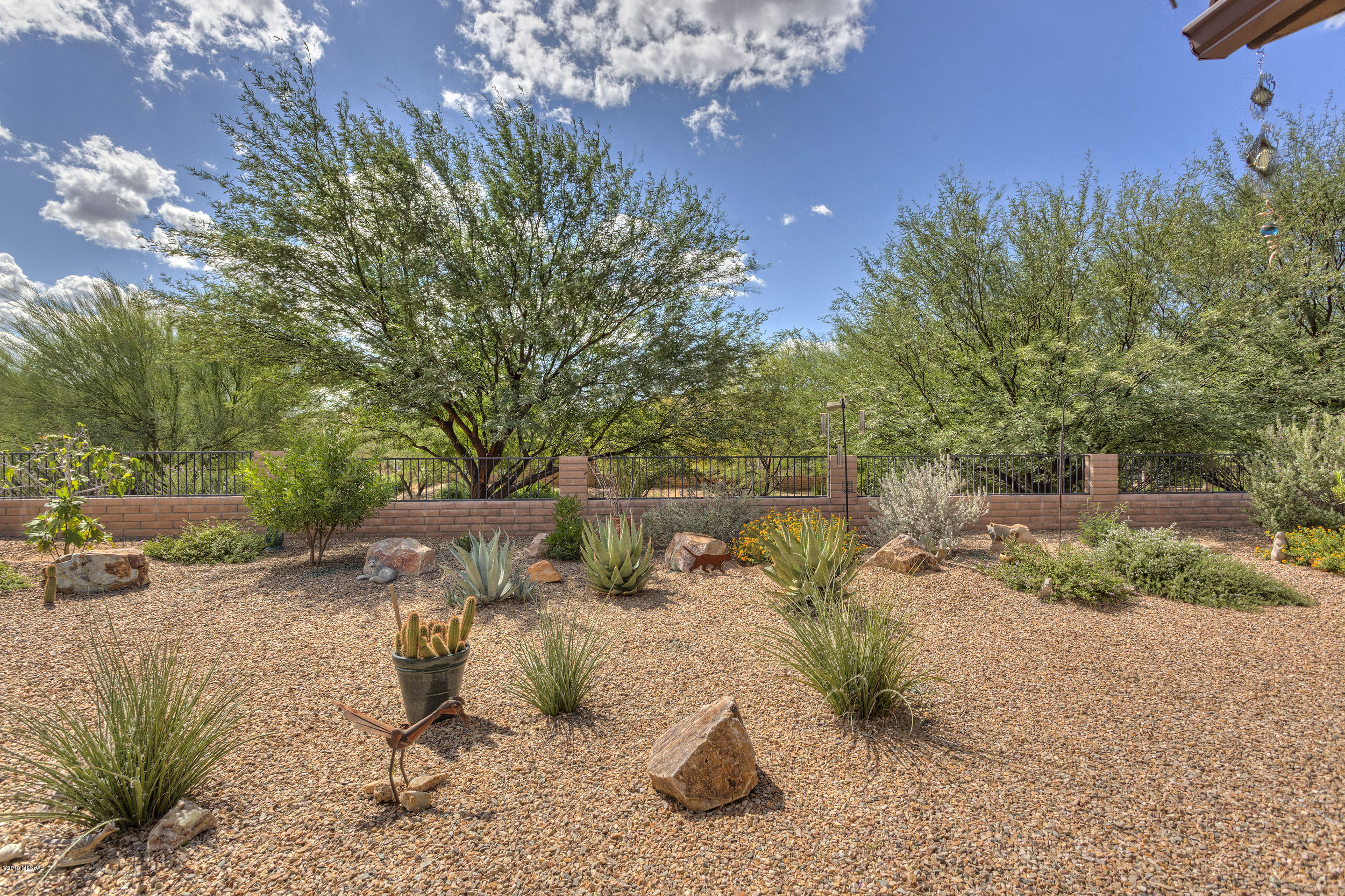 Popular Agave Model located on a beautiful lot backing up to dense common area wash.  Garage and Golf Cart Garage extended by 4' and feature expoxy floors, overhead storage, service door, workbench and soft water system.  The extended patio is perfect for entertaining or watching a sporting event on the wall mounted tv.  2 bedroom 2.5 bath home has split floor plan and two en suite bedrooms. Staggered cabinetry, granite counters and stainless steel appliances makes this open floor plan a dream for the chef. Custom tile everywhere except the bedrooms, den has beautiful built in Queen Murphy Bed.  Hunter Douglas shades throughout. Laundry room has cabinets upper/lower and utility sink, washer/dryer convey with home.