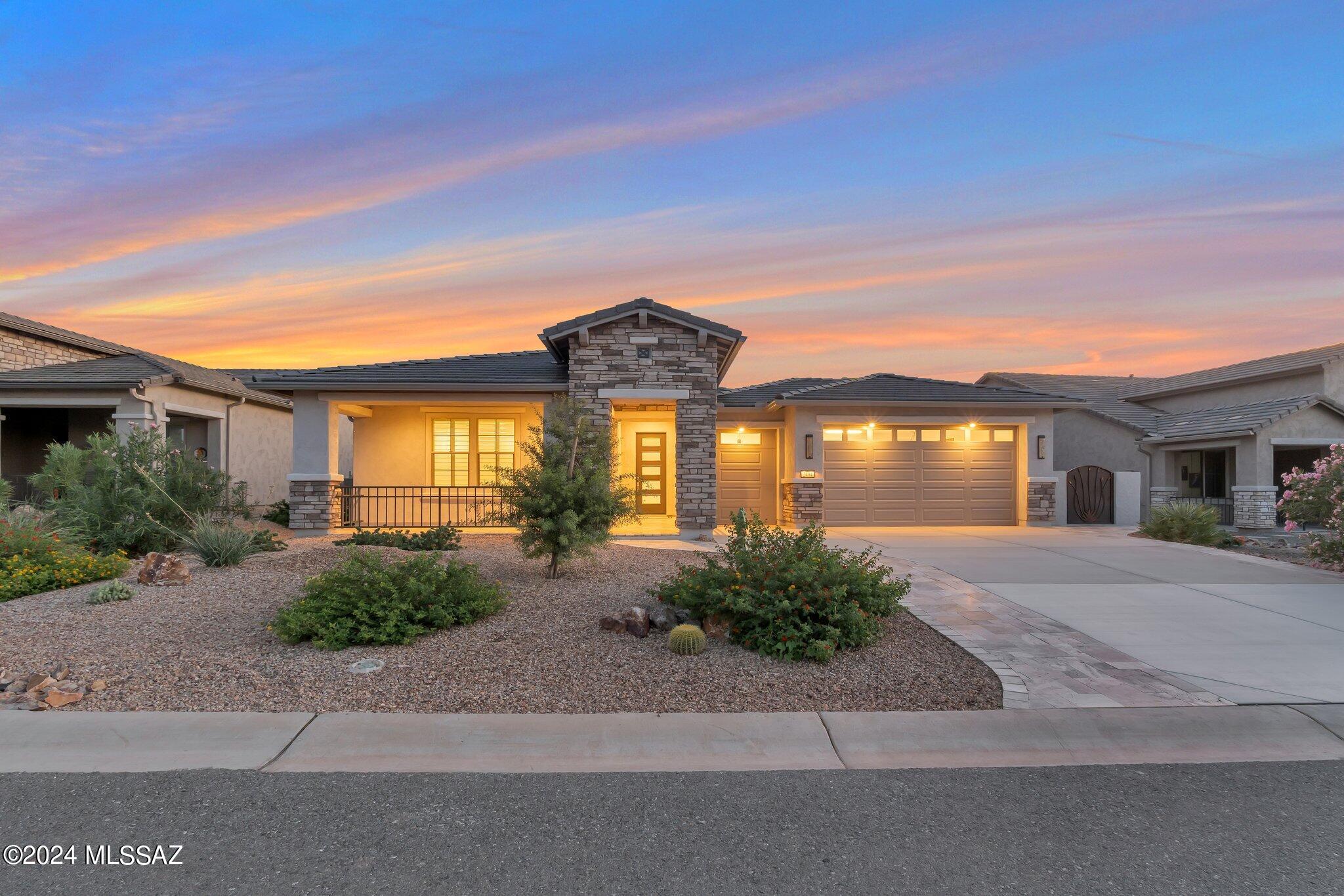 Welcome to the ultimate in luxury living, where every detail of this 2022-built masterpiece has been meticulously crafted to perfection. The home is surrounded by a stunning landscape, with silver travertine pavers leading up an extended driveway, accented by additional stacked stone for enhanced curb appeal. Imagine yourself enjoying a morning coffee on the inviting front patio porch. The backyard is a true oasis, offering a covered patio perfect for gatherings around a mesmerizing gas fireplace, complemented by a built-in BBQ and a putting green. The views of the golf course and mountains are nothing short of astonishing. For added convenience, the back patio features electric roll-down screens, while the dining room is equipped with a roll-down shade. Step inside to a gourmet kitchen that is the heart of the home, featuring a wet bar, a wine refrigerator, and top-of-the-line GE Monogram appliances. The center island boasts honed marble, while quartz countertops are elegantly spread throughout. A spacious butler's pantry provides ample storage. Custom lighting illuminates every corner, with temperature-controlled ceiling fans adding comfort throughout. Whimsical tile accents the guest bathroom, laundry room, and foyer, while luxury plank vinyl flooring ensures easy maintenance. Plantation shutters grace the windows, and the walk-in closets are outfitted with custom closet systems. The showers are tiled with intricate deco details, and even the baseboards have been upgraded. The expansive 3-car garage is an enthusiast's dream, featuring epoxy-coated flooring, a water heater with a recirculating pump, and a workshop area complete with top-tier cabinetry. This exuberant home offers a blissful retirement lifestyle in the vibrant Quail Creek community, where friendly neighbors and a plethora of clubs and activities, from pickleball and golf to fitness centers, heated pools, and an Arts and Creativity center, await. Live the life you've always dreamed of in a place where luxury meets comfort.