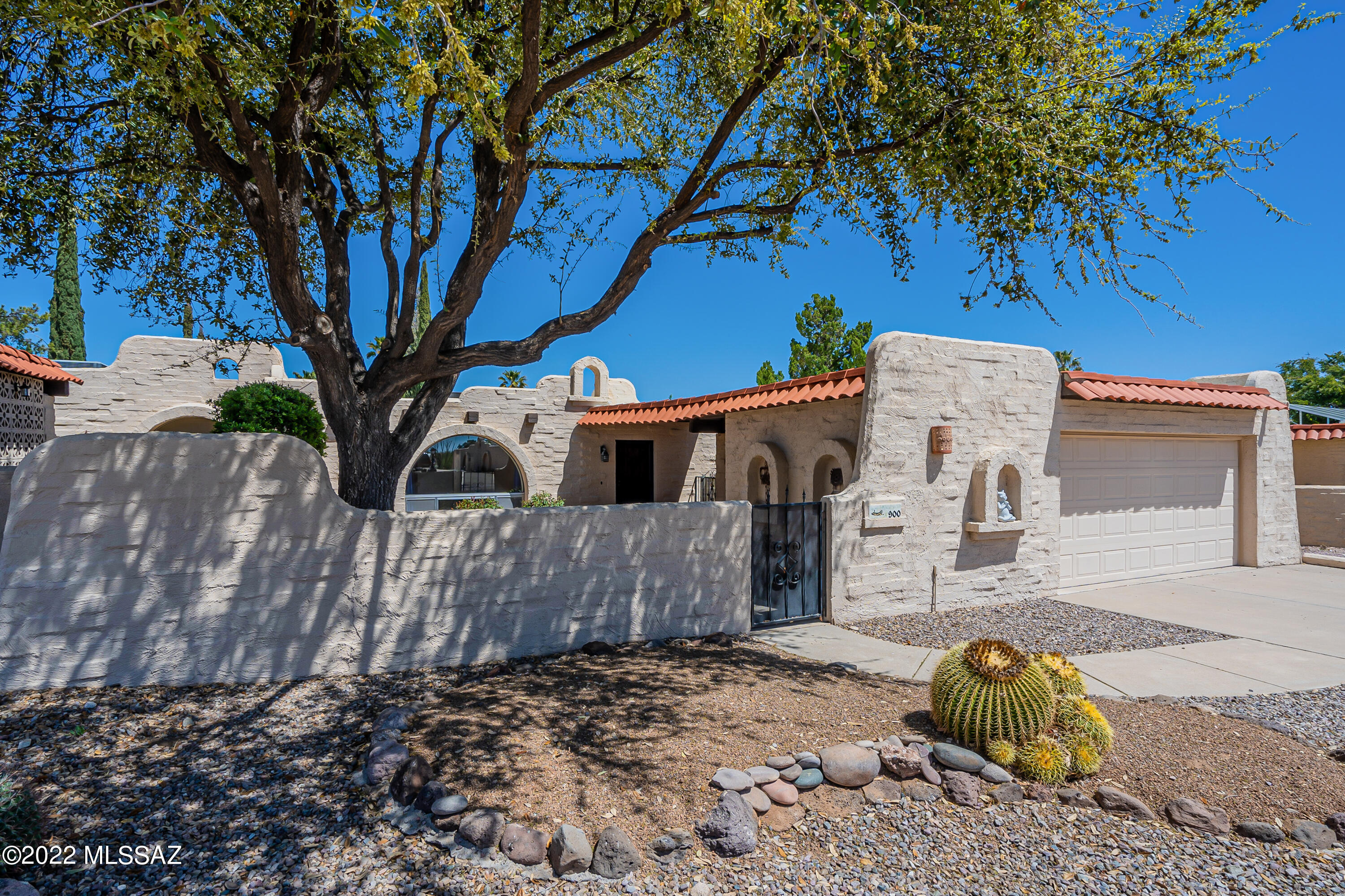 Displaying the charm of a historic Barrio, you'll love the Spanish Colonial architecture with its mission bell niches and Vega beams protruding above the large archtop window. Like a stroll through old Mexico, the open-air courtyard will make you feel like you're stepping back into the past. Step inside to find an immense living room offering courtyard views through a charming archtop window while a huge skylight showers natural light onto the beautiful Saltillo floor tile.  The adjoining dining area has plenty of room for entertaining and has access to the covered patio to bring in a fresh desert breeze.  The kitchen has stainless appliances and dazzling quartz countertops that wrap your kitchen in abundant counter space with an easy clean under-counter dual basin sink and contemporary pull-out faucet.  Sliding pocket doors and bifold wood doors give you the option for a quiet den, office space, or hobby/craft room just off the living room.  In the expanded owner's suite, you'll find wood laminate flooring and an updated bath with step-in shower with beautiful custom tile work.  The southwest charm continues under a huge covered patio where Saltillo tile extends your living spaces and slump block perimeter walls provide total privacy. And you'll have fresh fruit anytime you want from your own orange, grapefruit, and lemon trees! Terrific community amenities for its residents include - pool, pickleball, walking trails, park and a Ramada for special occasions and parties.
