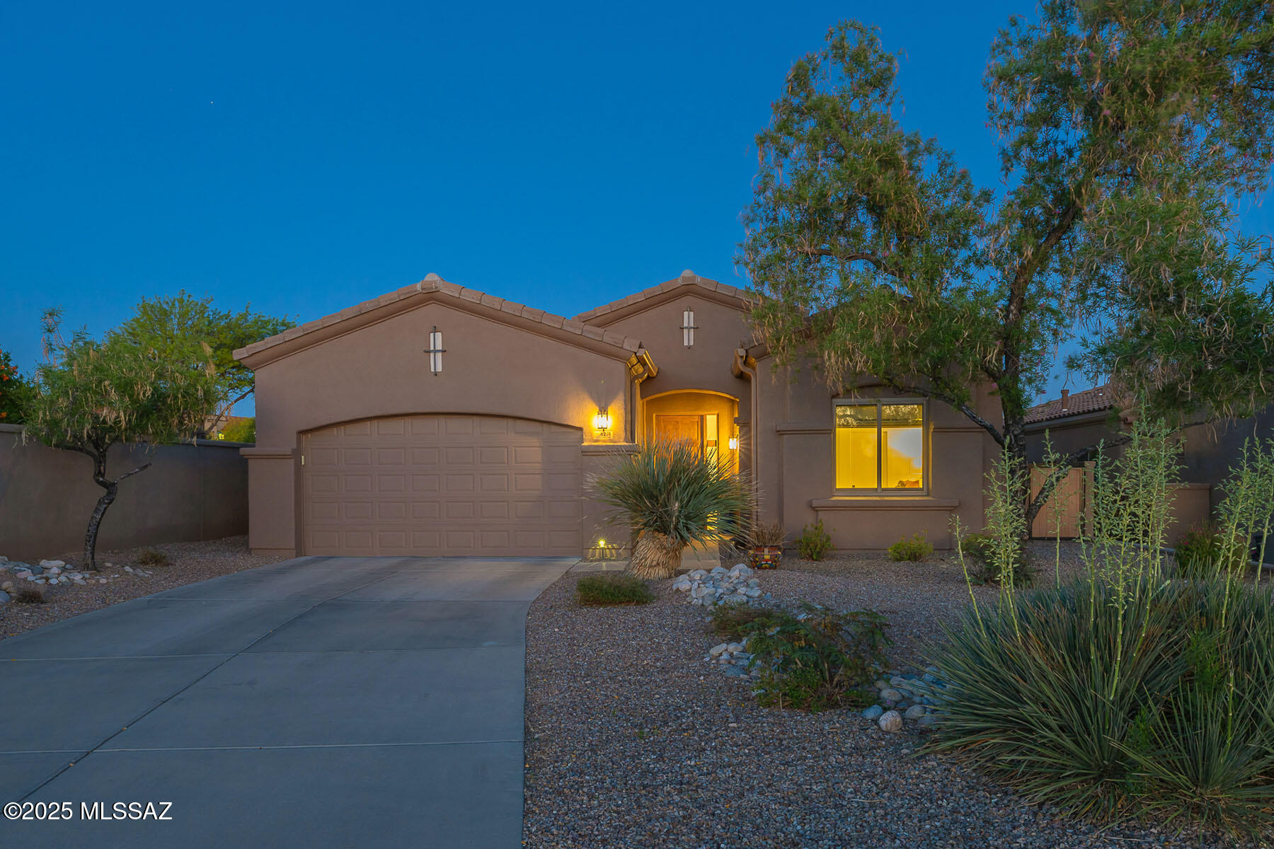 Located in the highly desirable gated community of The Villages of La Paloma, this fully renovated 3-bedroom, 2-bath home blends timeless design with modern comfort and scenic golf course views. A custom 8-foot solid walnut entry door welcomes you into a thoughtfully designed 2,021 sq. ft. layout that flows effortlessly throughout.

Two guest bedrooms and a full bath are positioned near the front of the home for privacy, while the main living space opens into a light-filled great room with a striking stacked stone fireplace. The adjacent dining area and fully remodeled kitchen create a perfect entertaining hub, featuring custom knotty alder cabinetry, sleek quartz countertops, and a complete suite of KitchenAid stainless steel appliances—all finished in smudge-resistant PrintShield, including a double wall oven, induction cooktop, and French door refrigerator. A central skylight and under-cabinet lighting enhance the clean, modern atmosphere.

Tucked away at the back of the home, the spacious primary suite includes a walk-in closet and a luxurious bath with marble tile shower, soaking tub, and a Toto self-cleaning toilet/bidet. The former fourth bedroom has been converted into a highly functional laundry and utility room with matching quartz surfaces, a deep sink, wine cooler, and second refrigerator.

Recent upgrades include a new HVAC system, dual-pane windows, solar panels, updated ceiling fans and lighting throughout. The professionally landscaped backyard backs directly onto the 3rd hole of the Hill Course, offering peaceful views and privacy. Community amenities include a resort-style pool and spa with a built-in BBQjust a short walk from your door.