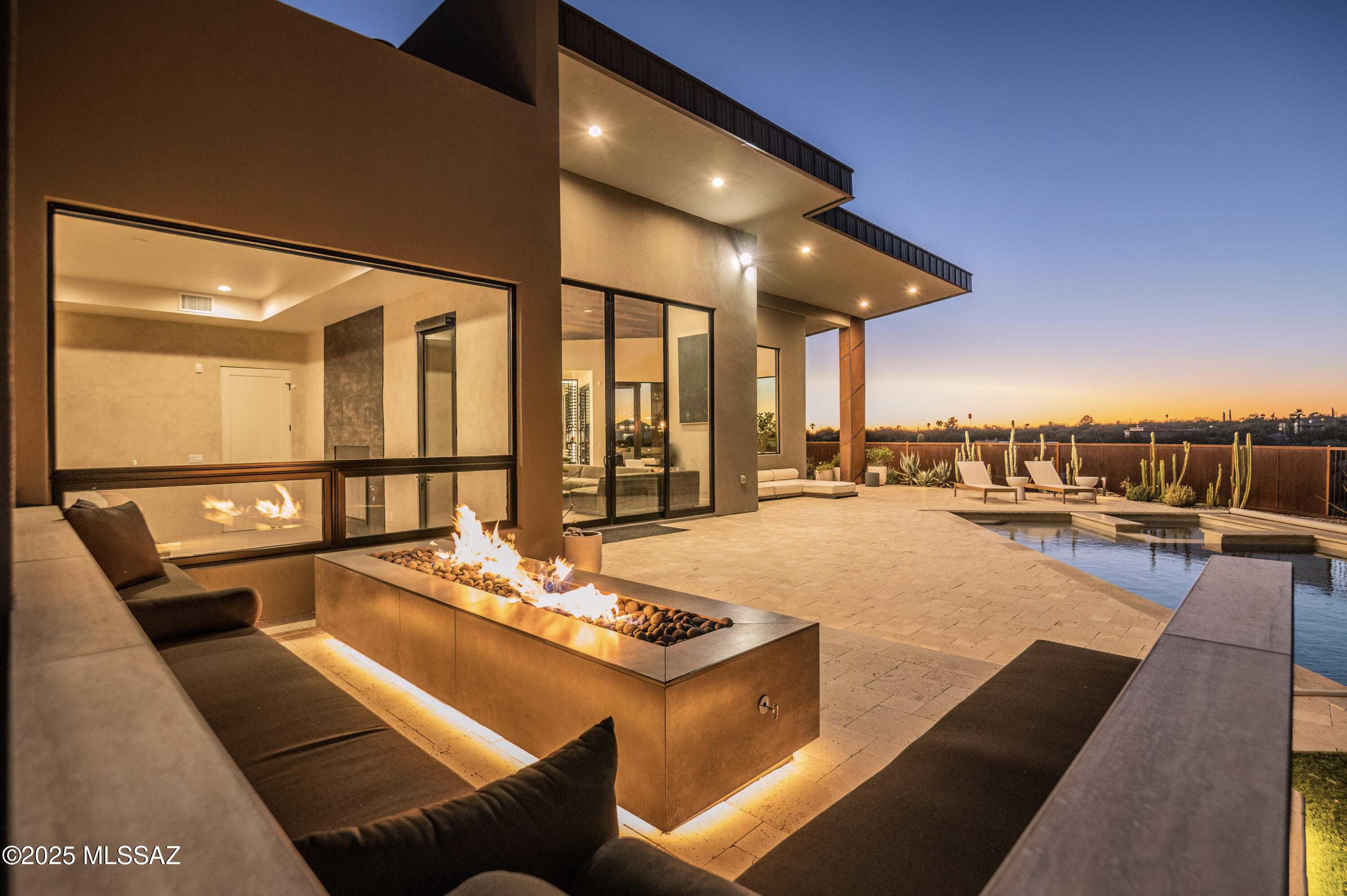 Established in Tucson's premier Catalina Foothills, this extraordinary contemporary residence embodies the very best of craftsmanship, custom finishings and refined desert living. The expansive picture windows fill the open living spaces with natural light, seamlessly blending the indoor and outdoor 360° panoramic views. The gourmet kitchen features stunning marble countertops, a large center island, and top-of-the-line stainless steel appliances. The serene primary suite includes a fireplace and spa-inspired bath area paired with stunning mountain views. Entertain and accommodate guests with the pre-installed Sonos sound system, smart heated pool and spa with automated safety cover, firepit lounge, and extended 3-car garage. Located near premier shopping, dining, and entertainment.