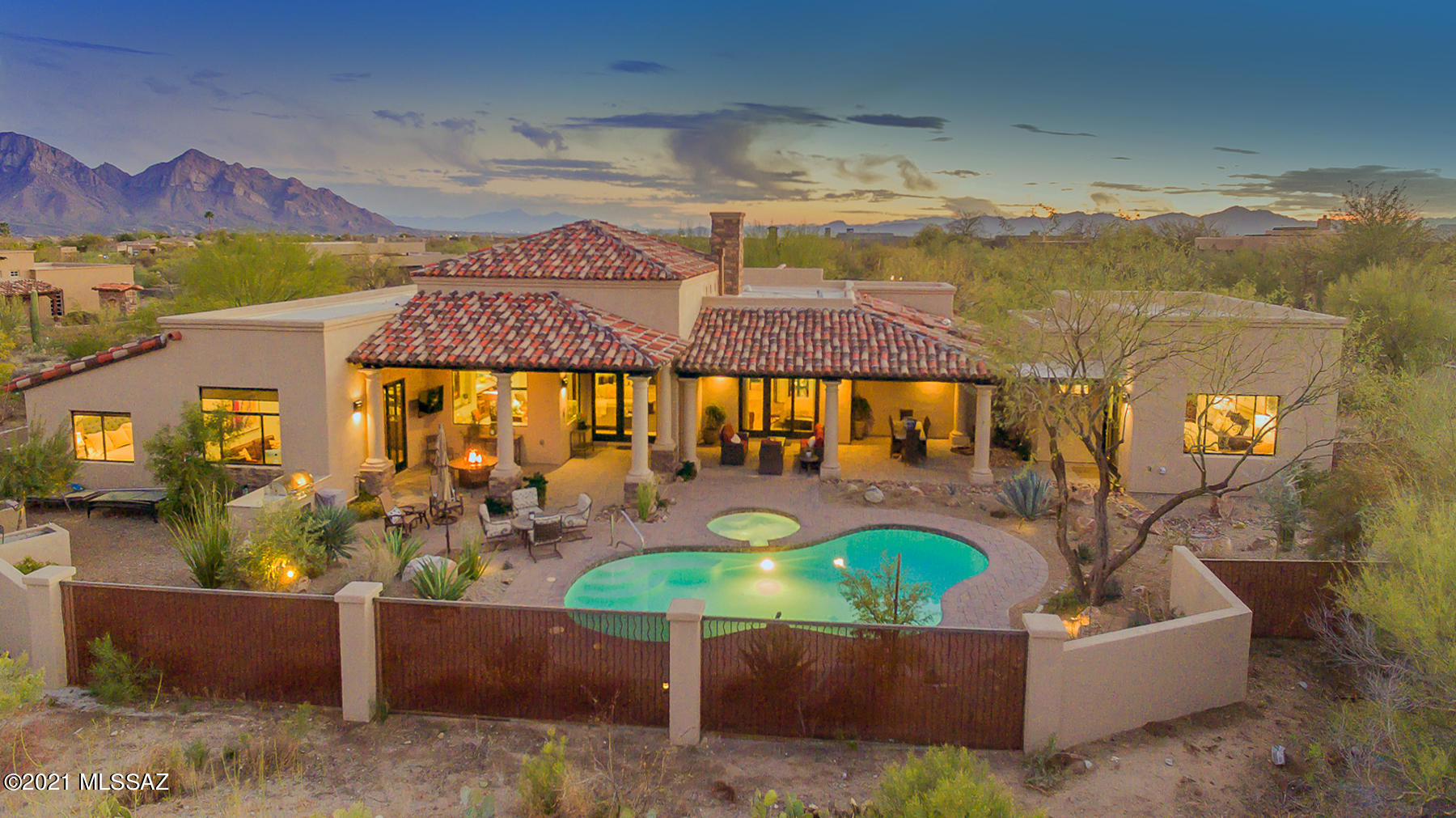 This stunning SW contemporary is located in the prestigious gated community of Stone Canyon offering 4,139 sq. ft. Enjoy this luxury home boasting 3 ensuite beds w/ office & private guest quarters. This private community offers resort-like lifestyle w/ Championship-level golf course, clubhouse, & more! Enter thru lushly landscaped courtyard to custom rustic iron/glass doors. Open design offers natural light & jaw-dropping mountain views perfect for entertaining w/ inviting fireplace in great room leading to gourmet  kitchen w/ Quartzite countertops & SS appliances. Beautiful marble & Karastan Villa Pointe wood flooring throughout. Spacious master suite offers sunken tub, walk-in steam shower, & custom glass doors leading to patio. Backyard w/salt water pool, spa, & built-in BBQ!