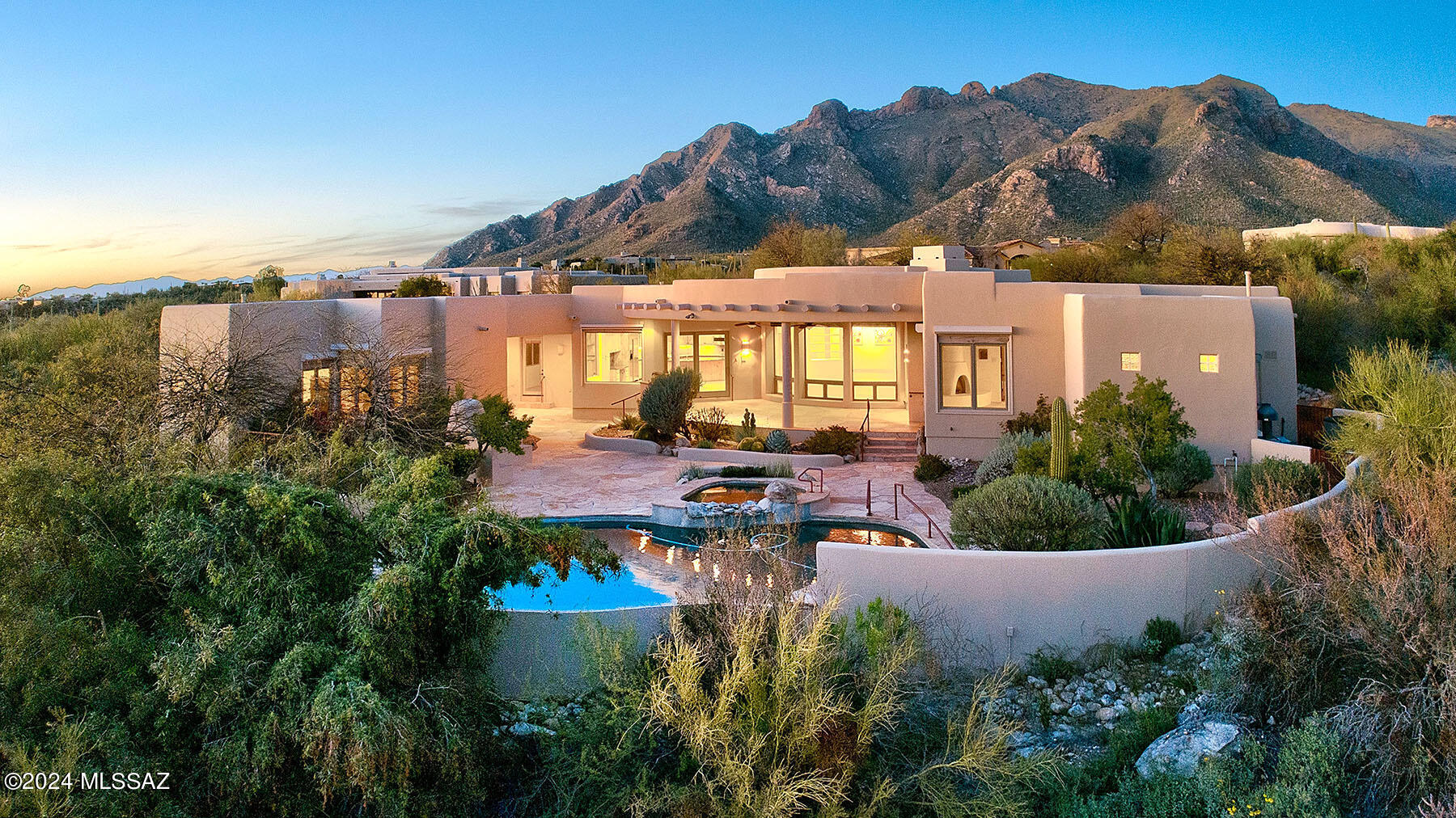 Experience authentic Santa Fe living in the gated community of Pima Canyon by Coronado Custom Homes. This home embodies all the Santa Fe charm with its viga-beamed ceilings, cedar-planked accents, skip-peeled Latilla ceilings, wooden lintels, niches, cedar cabinets and doors, and flagstone floors & large floor to ceiling windows. Built around a stunning circular great room with Kiva fireplace, this home features a gourmet kitchen with granite slab countertops, center island, cedar cabinetry and SS appliances, stone bathroom countertops, and a stone pedestal with a vessel sink in the powder room. Smooth stucco, freshly painted inside and out, roof under warranty, floors resealed , newer HVAC. Extra large primary suite includes ensuite bathroom with double vanity walk-in shower, walk-in dressing room/closet and fireplace, 2nd bedroom is used as an office. 3 bedroom enjoys and ensuite bathroom & backyard access. Backyard has large covered patio and bbq, Pebble Tech Pool & Spa & water fountain and Kiva fireplace. Additionally, there's a separate 451-square-foot guest house that includes a kitchenette, murphy bed & ensuite full bathroom. 360 degree views of all of the mountain ranges & city lights from the upper deck. 3 car garage with ample storage on .84 acre lot!