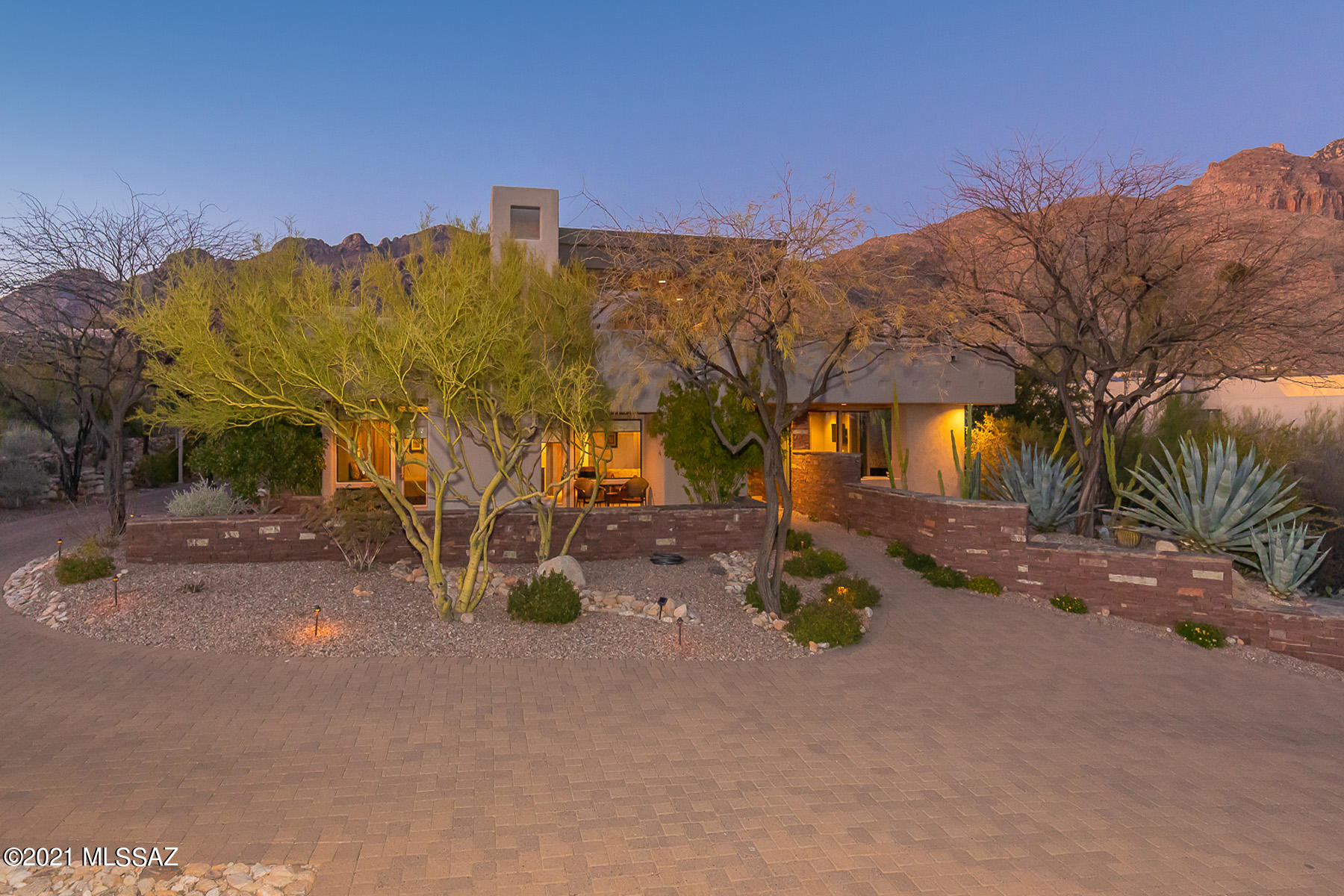 Panoramic mountain and city light views highlight this spacious custom estate in gated Pima Canyon Estates. Nestled against the Catalina Foothills, this stunning 3BD/4BA (4,955 sq ft) home designed by architect David Tyson boasts 5 fireplaces, extensive stonework, beamed ceilings and skylights, plus brick paver driveway, front courtyard and patios. Master suite hosts a luxury bath with exercise room plus office/den. Two guest suites share a private den. Expansive Great room hosts a gourmet kitchen w/butler's pantry and wet bar. Formal dining room lies beyond. Watch the setting sun upon the Catalinas from a resort worthy yard with pool, or view twinkling city lights from covered observation deck. Surrounding native desert landscape rounds out the beauty of this truly one-of-a-kind home.