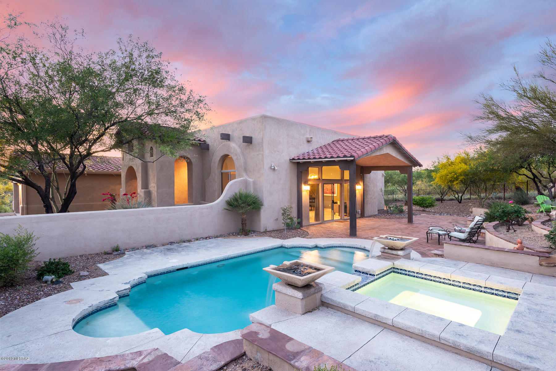 Located in gated Coyote Ridge, one of ORO VALLEY'S MOST DESIRABLE NEIGHBORHOODS-4BD/3BA private residence w/3-car garage on 1.28 acres with stunning Mountain Views. Follow long driveway to high up homesite. Bright and open layout w/upgraded amenities:24'' travertine floors (3 rooms w/bamboo floors), plantation shutters, custom interior paint, lighting & fans. Soaring great room with fireplace, tall windows & open kitchen w/granite, breakfast bar, custom cabinetry & formal dining. Spacious master with kiva fireplace, huge closet and direct access to central courtyard with Tivoli fountain.east-facing backyard with 2006 custom salt-water pool & spa (self-cleaning), large paver patio & fire pit.