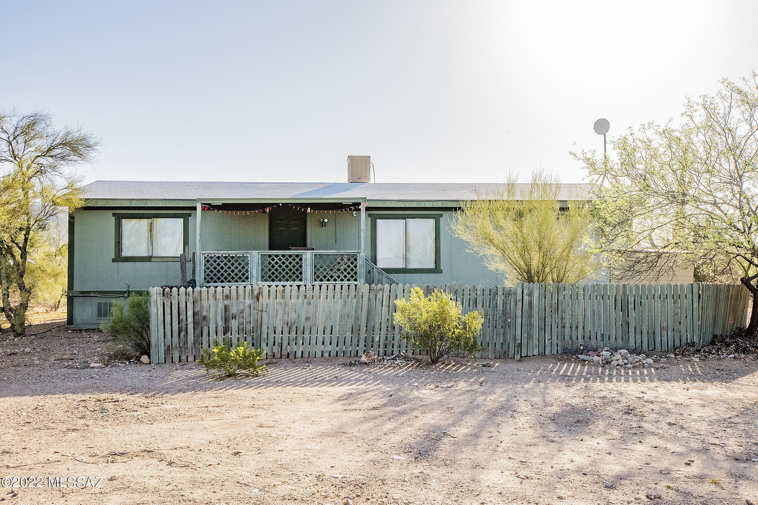 If you want to live out in the country, this is it! This 3 bedroom/2 bath manfactured home sits on .70 acres out west of Tucson Mountains! Spacious and open floor plan with a nice sized great room that opens onto the dining area. Nice sized kitchen with a separate laundry room. This home comes with a complete set of appliances. Also you have a split bedroom floor plan with the master bedroom on the north end of the home and the 2 guest bedrooms are on the south side of the home.  there are wood laminate floors throughout this home. 1Also a large wood deck in the front of the home for relaxing and enjoying the desert. You have great mountain views from many places in the home. You could move in tomorrow.