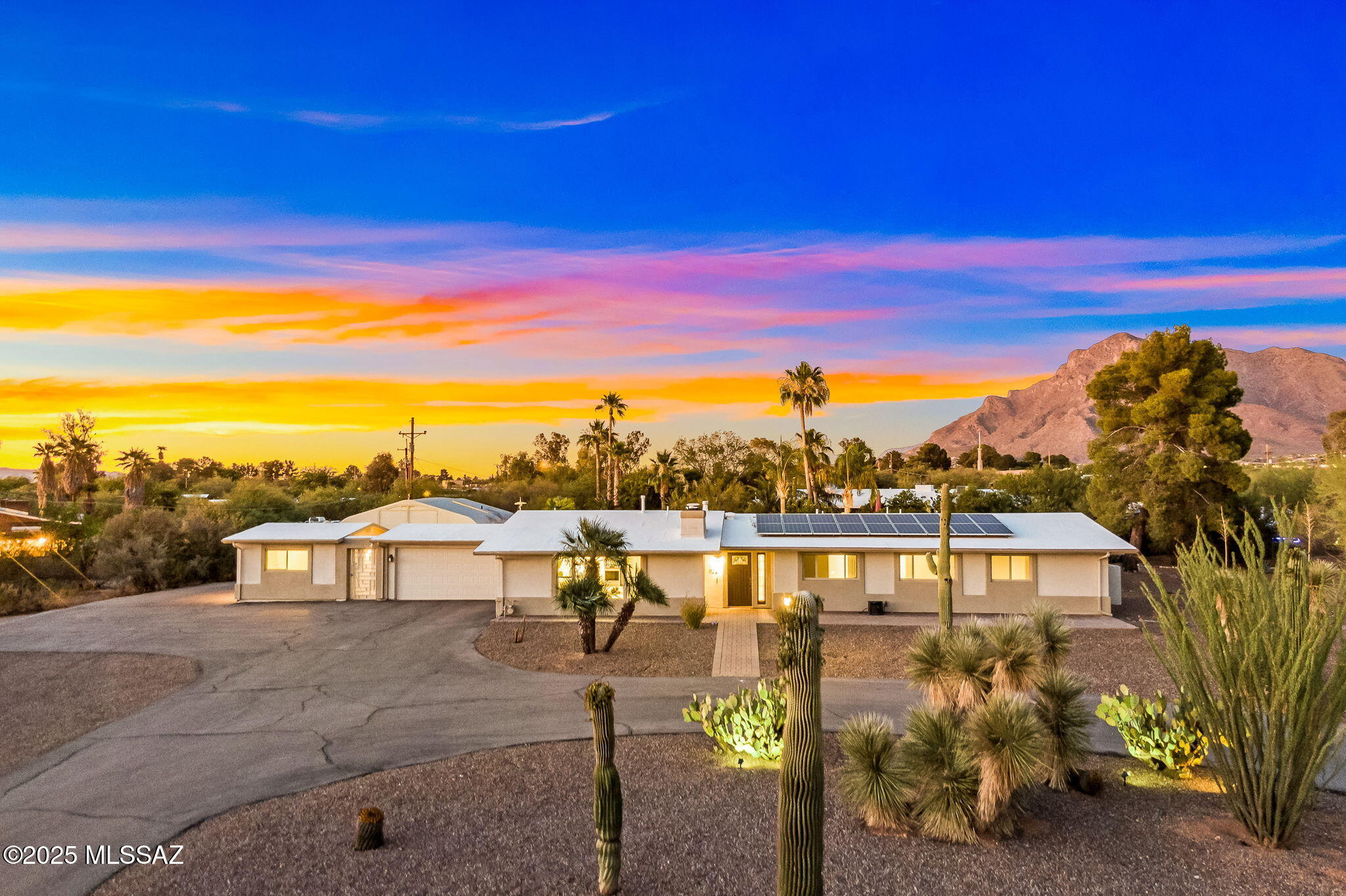Welcome to this beautifully reimagined mid-century ranch, perfectly positioned on nearly an acre of land with dramatic mountain views as your everyday backdrop. Meticulously updated, this 1959 classic blends timeless architecture with modern amenities, offering a main residence, separate guest casita, versatile studio space, and exceptional garage capacity including an attached 2-car garage and a detached workshop. Located in a quiet, scenic neighborhood, this property delivers the ideal mix of privacy, space, and style. Step into a welcoming foyer that opens to an expansive living room natural light and cozy contemporary gas fireplace. The heart of the home is the tastefully updated kitchen, showcasing granite countertops, stainless steel appliances, and ample cabinetry. A cozy breakfast area with a wet bar seamlessly connects to the adjacent family room, offering access to the outdoor living space. The spacious primary suite is a true retreat, featuring a private sitting area, large walk-in closet with built-in organizers, and a spa-like bathroom with dual granite-topped vanities, Craft Made cabinetry, a designer tile walk-in shower, and an oversized garden tub. The second bathroom has also been thoughtfully remodeled with updated cabinetry, granite counters, new lighting, and fixtures. Recent upgrades include tile and carpet throughout, fresh interior and exterior paint, brushed nickel plumbing fixtures, all newer six-panel interior doors, and modern window coverings. Additional structures include a charming 297 sq. ft. studioideal for an art studio, home office, or craft space and a detached 27'7" x 17'2" RV garage/workshop with room for toys or a full workshop setup. A separate one-bedroom, one-bathroom casita offers flexible space for guests, multigenerational living, or rental potential. Outside, the property is equally impressive. Enjoy sunsets and mountain views from the expansive backyard with a covered patio, sparkling pool, mature desert landscaping, citrus trees, a dedicated dog run, and plenty of space for outdoor entertaining. A solar system adds energy efficiency to this well-maintained and thoughtfully upgraded home. This is a rare offering that blends mid-century charm, modern convenience, and stunning natural beautyready to welcome its next owner.