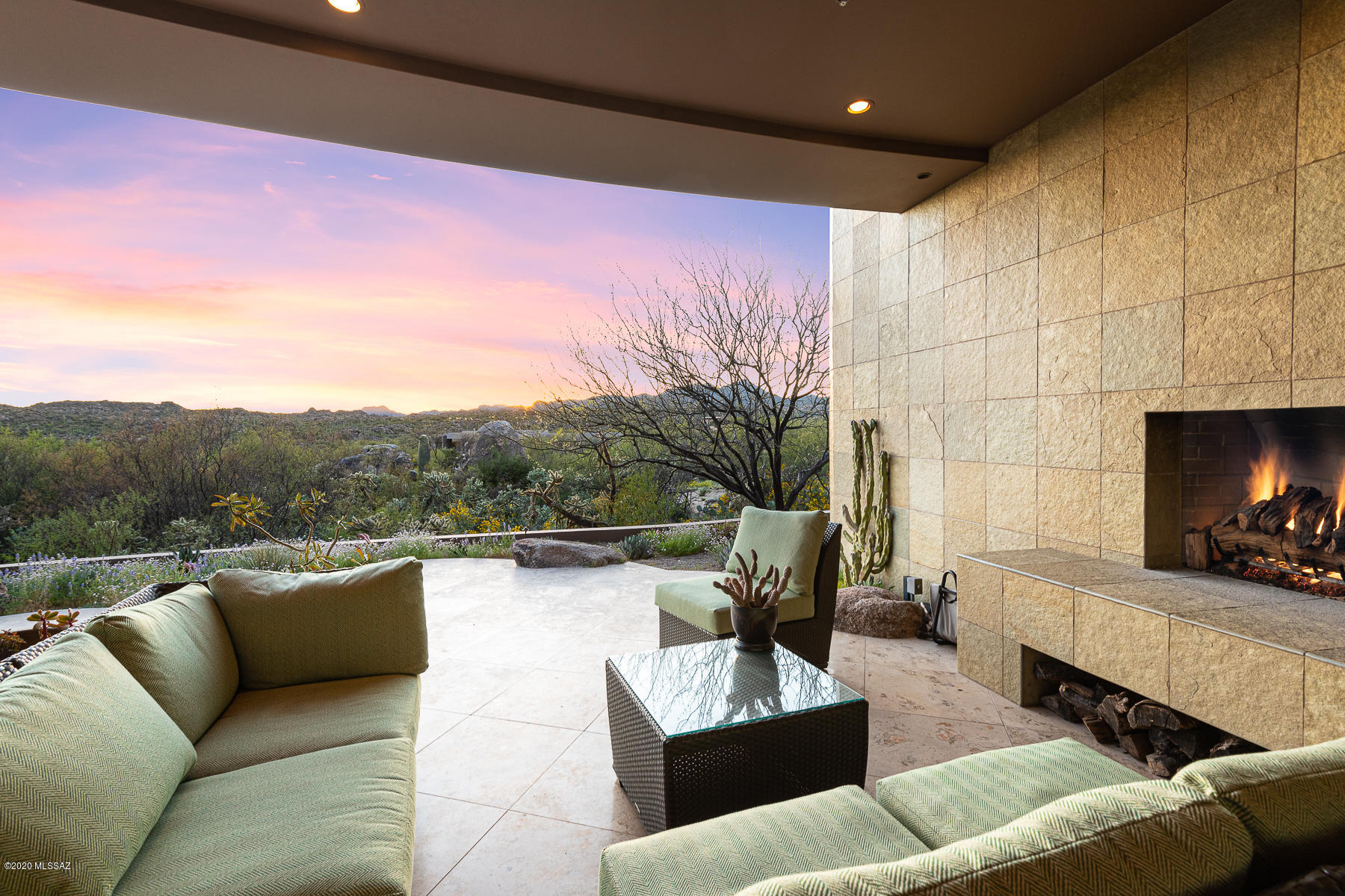 Exquisite desert contemporary custom home designed by Ron Robinette  located at the end of a cul-de-sac on a private 1.75 acre lot protected by greenbelt corridor with extraordinary mountain & sunset views  Luxury & nature intersect flawlessly on this breathtaking elevated homesite w/ masonry-built home w/ guest house located in the exclusive, guard-gated Honeybee Ridge Estates near the acclaimed Stone Canyon Golf Club.  Long driveway lined in pavers leads to gated courtyard w/ colorful native plants & cacti.  Walls of windows frame panoramic, unobstructed views of the Tortolita Mountains as you enter the main living area w/ 15 foot ceilings & Portugese Limestone floors. Living room & library each w/ masonry fireplaces. CLICK MORE for additional information.. Formal dining room with custom built-in buffet is adjacent to 6200 bottle wine room with large viewing window.  Gourmet kitchen with oversized granite island with prep sink and breakfast bar.   Features include custom cherry cabinetry, side by side Subzero refrigerator/freezer, Dacor gas range with double oven, warming drawers and microwave, mielie and fisher paykel dishwashers, water filtration system and large walk-in pantry.  Large breakfast area with granite buffet and built-in desk area. Luxurious master suite with gas fireplace and private patio has his and hers bathrooms and walk-in closets.  "Her" bathroom with garden tub with fireplace and desert views, heated travertine floor and towel warmer.  "His" bathroom with open shower with 2 shower heads for surround shower and heated limestone tile floor. Spacious home office with extensive cherry wood built-ins, display shelves, filing cabinets and view overlooking front courtyard.  En-suite guest bedroom with walk-in closet and upgraded bathroom with granite and stone finishes has sliding door to back patio. Powder room with upgraded finishes off entry for guests. Deep covered patio with recessed lighting and wood-burning fireplace ideal for enjoying the indoor/outdoor Arizona lifestyle.  Outdoor kitchen has Lynx grill, double burner gas stove, sink with disposal and refrigerator.  Impressive detached one bedroom guest house with kitchenette, fireplace and lovely patio with Pusch Ridge views has it's own 1-car garage.  Main house has oversized 3- car garage with tons of storage, owned solar system and automated shades.