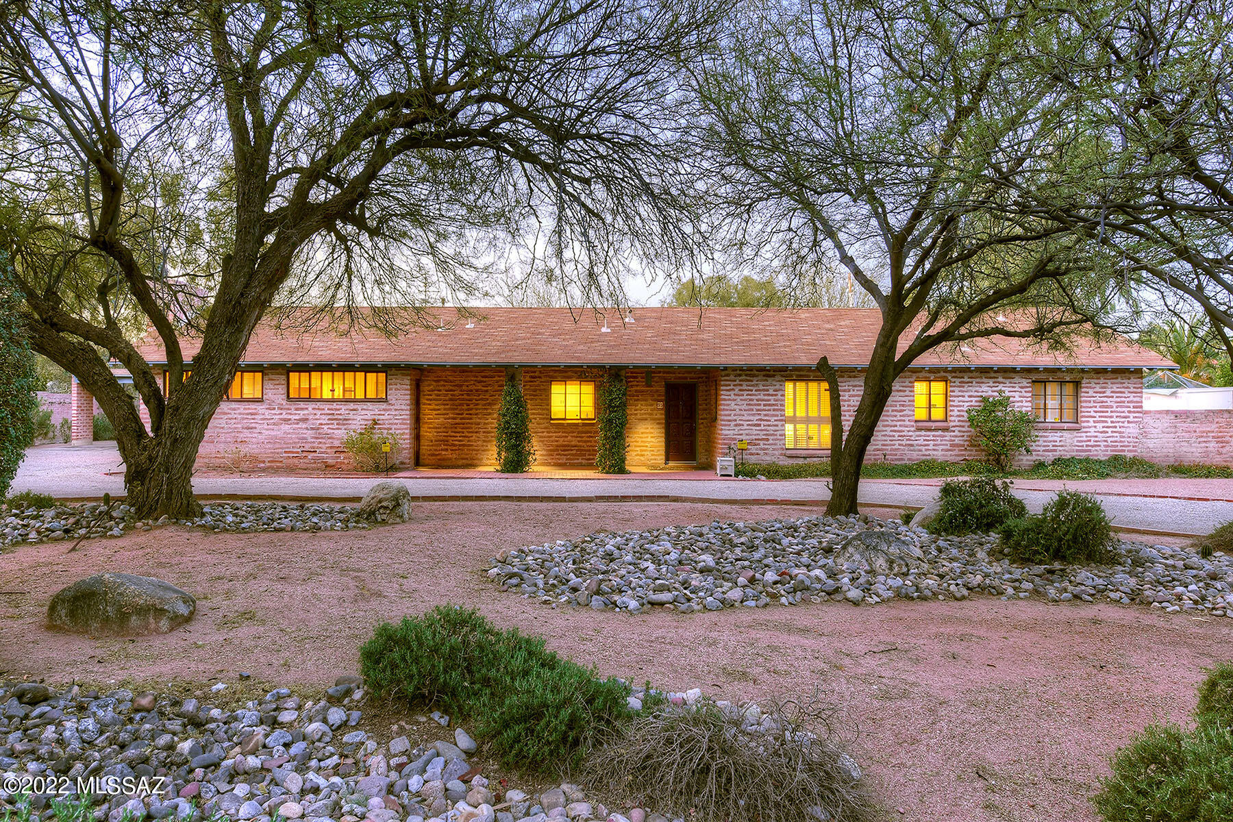 Lovely El Encanto, Sonoran Ranch home.  This handsome burnt adobe home sits on a .92 acre lot in a beautiful cul de sac & has been lovingly owned & maintained since 1977. Built in the 1950's this home has all the ear marks of the era & is a great opportunity to renovate the home to your own unique style.  2613 sq ft offers a 4 bedroom 2.5 bathroom + a large living room w/a FP, galley kitchen and a large separate family room with a FP, built in book cases. Large storage room.  3 bedrooms jack & jill with bathrooms. Large covered brick patios over look the pool. The land extends far beyond the interior wall  & has mature desert flora. Separate double carport plus storage, plus tons of off street parking.  This home is on the National Historic Register for owner occupancy