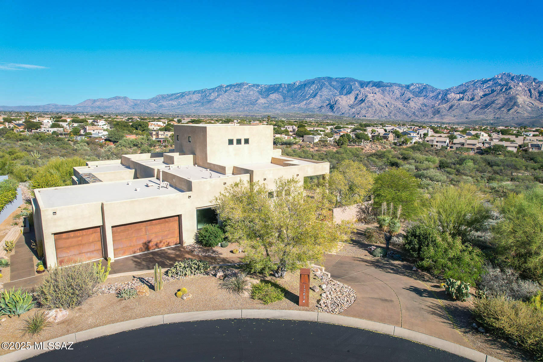 LUXURIOUS CUSTOM ESTATE nestled within the gated, picturesque community of Vistoso Pointe affords architectural detail, flexible living spaces plus uncompromising desert, mountain & city light views. Elevated, Premium East-facing lot with no one directly behind affords ultimate privacy. Featured are 4 bedrooms, 2.5 baths plus 3,531 sq ft of elegant living space including a spacious, upper level office/5th bedroom. Striking courtyard entry displays an expansive wrought iron gate with slate tile surround to welcome your guests. Inviting foyer flows effortlessly to formal dining room and large gathering room displaying a soaring, recessed ceiling, slate tiled fireplace flanked by art shelves, plus walls of windows accentuating the magnificent views. Gourmet kitchen hosts large center island, in-wall ovens and gas cooktop, open dining area with views plus outer island with wine cooler. Neutral stone floors highlight main living areas with granite countertops in kitchen, laundry & baths. Expansive Owner's Suite with rear patio access hosts a luxury spa bath with dual vanities, soaking tub, plus walk-in rain head shower and custom closet. Third bedroom is ideal as a Den/Media room while expansive upper-level Office accesses private balcony touting forever views. Extended laundry with sink adjoins powder room and 3-car garage with rustic iron doors and storage cabinets. Additional amenities include rich-hued cabinetry and doors, carpeted bedrooms, backlit art alcoves, fire sprinklers plus rolling sunshades off dining room. Retreat to a rear covered patio with outer cobblestone pavers, built-in grill station, firepit with curved bench seating, plus professional landscaping and spectacular views. Perfect for the most discerning buyer!
