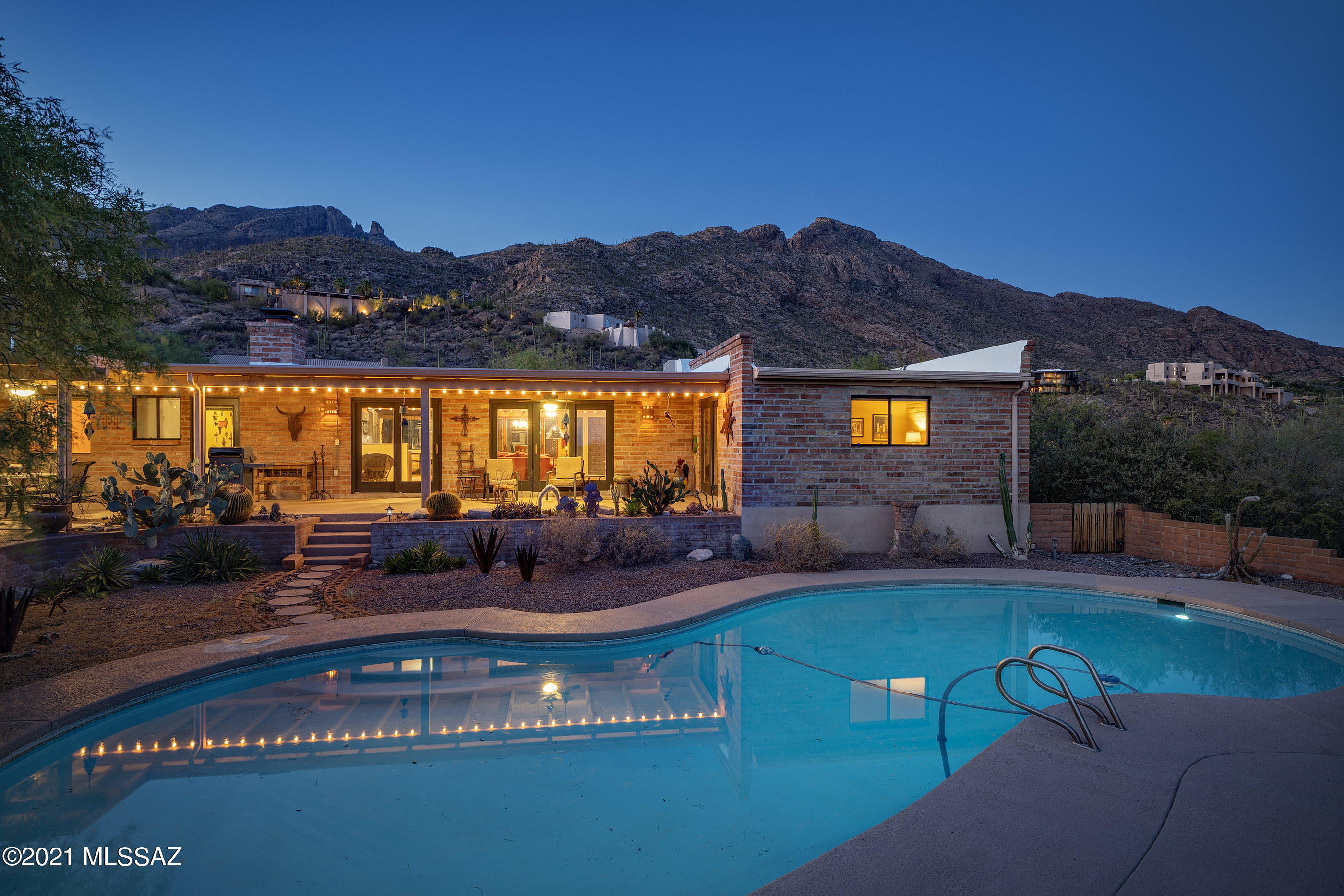 Beautiful adobe home with the classic architecture you'll love.  Exposed brick, concrete floors, yet tastefully updated.  Two owner suite's, and two additional bedrooms.  Enjoy the city lights as you overlook the tranquil pool area from your long covered patio, and the Catalina mountain views and Finger rock from the front of the home.  Nestled in natural desert landscape, the home is secluded yet minutes from your favorite amenities.