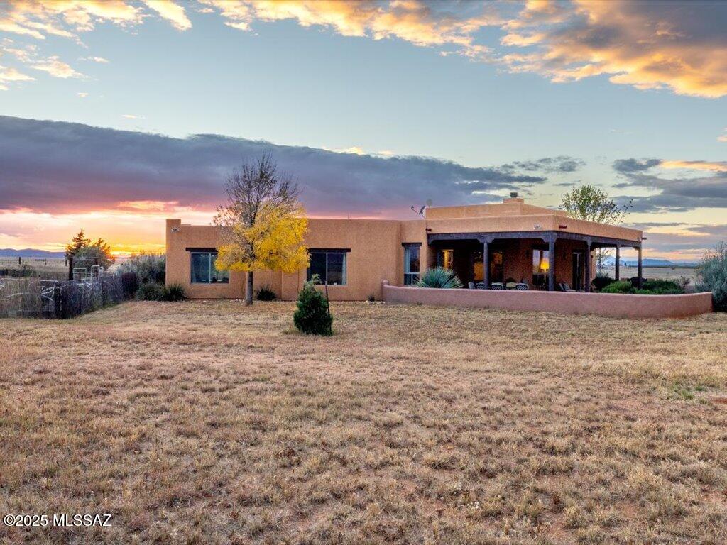 Santa Fe style home on 20 Ac, along winery row. The home shares large views in every direction, Once entering from either courtyard, home has a bright open feel created by tall ceilings large headers with many windows throughout each with a view. Solid wood doors and beehive fireplace complete the charm. The concrete sealed floors is the answer for easy care flooring, low maintenance. The garden courtyards with covered porches make for a  perfect space to enjoy outside living. 880 sq ft Barn/workshop A must see, lot can be subdivided. The property has 400 amp electrical service, Private well, fencing,  metal equipment or RV storage with power.  Note: Adjacent 20 ac to the West Available!