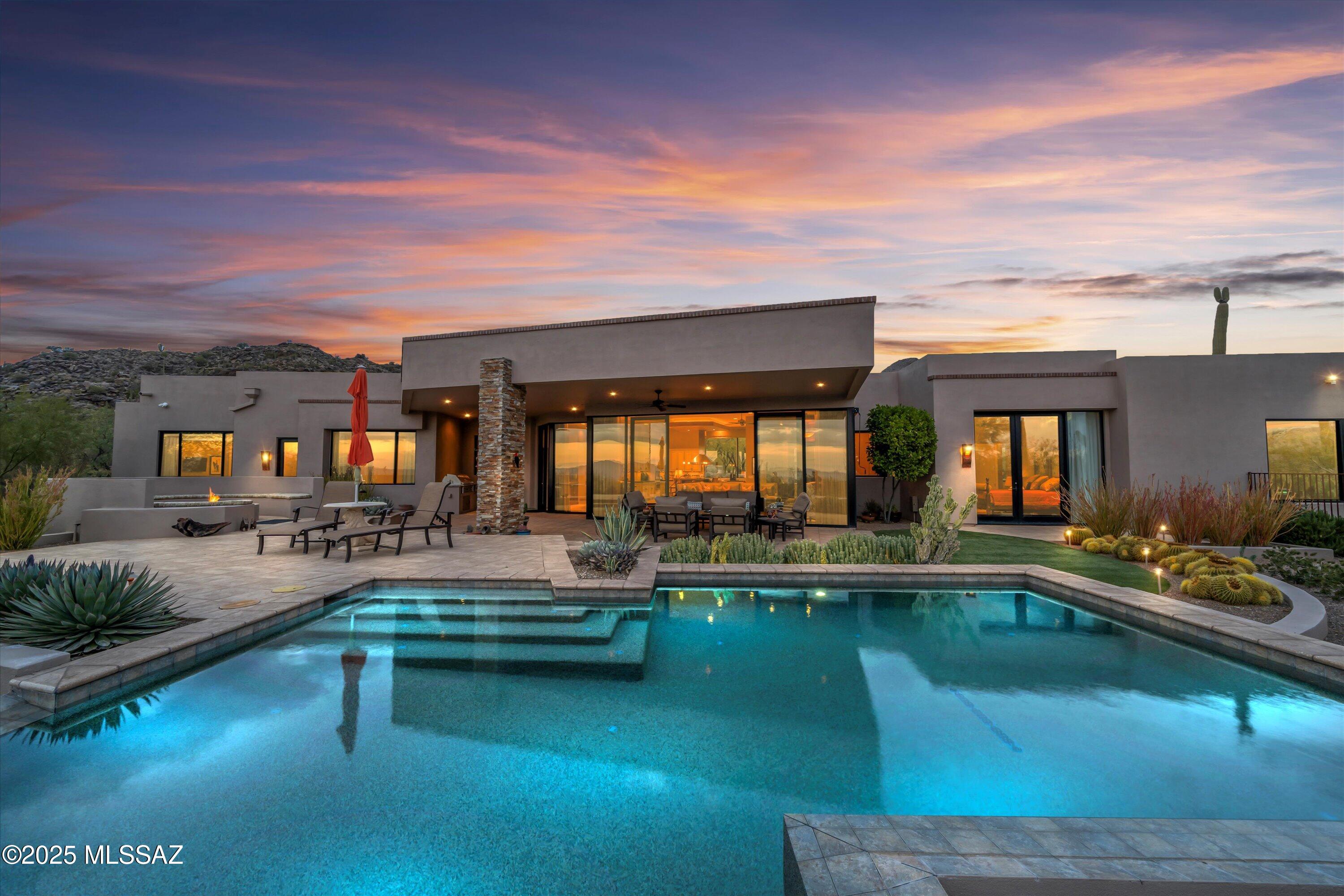 This stunning soft contemporary, nestled in the gated enclave of Canyon Pass at Dove Mountain is the perfect blend of superb craftsmanship & detailed design, creating sophistication throughout. Designed by Marc Soloway, built by Mike Wachs with interior design by Andrea Wachs, this home is perfectly situated to capture beautiful city lights from the south facing backyard and mountain views to the north.
This elegant 3BR/4BA property features ensuite bathrooms for all three bedrooms, a powder room, an office and an exercise room, along with an open-concept floor plan designed for modern living. The bright and airy Great room is ideal for relaxing or entertaining, while the chef-inspired kitchen boasts leathered granite countertops, ample cabinetry with Wolf, Sub Zero and Miele appliances. The Master Suite is a true retreat, with dual closets, exercise room, dual vanities, jetted tub and massive, walk in shower.
Two additional ensuite bedrooms, along with a dedicated office, provide flexibility for guests or family needs.
Outside, the expansive backyard offers a pebble tec, knife edge pool surrounded by Corallock pavers, a gas firepit and built in Lynx BBQ with sideburner, providing a serene setting for the beautiful Arizona evenings.
This magnificent property is completed by an expansive 3 car garage with more storage cabinetry than most people could fill, plus a heated and cooled workshop.  Electricity bills are virtually nonexistent with the owned solar, while the water in the house goes through a softener.
With its close proximity to the world-renowned Ritz Carlton at Dove Mountain, as well as the Gallery Golf Club, hiking trails and other nearby amenities, this fantastic home promises endless opportunities.