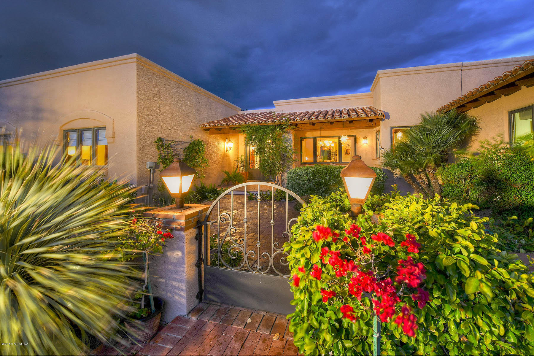 Beautiful classic custom home in the presitigious gated community of Lapaloma. Awesome mountain views & a lovely guest house on a very private lot. As you enter through the gorgeous custom doors you will be in awe of the beautiful details thru-out. Not only is there a lovely spacious guest house, but each bedroom has an ensuite bath. You'll love the large fabulous resort-like master that opens to the backyard & features its own cozy fireplace & spa like bath. The kitchen is a chef's dream, w/ dual islands & custom cabinetry w/ large walk in pantry. The gorgeous lush backyard is complete w/ tranquil, secluded patios, an organic vegetable garden, pool, spa & gorgeous landscaping.  This home is truly the Arizona Inn of the foothills.