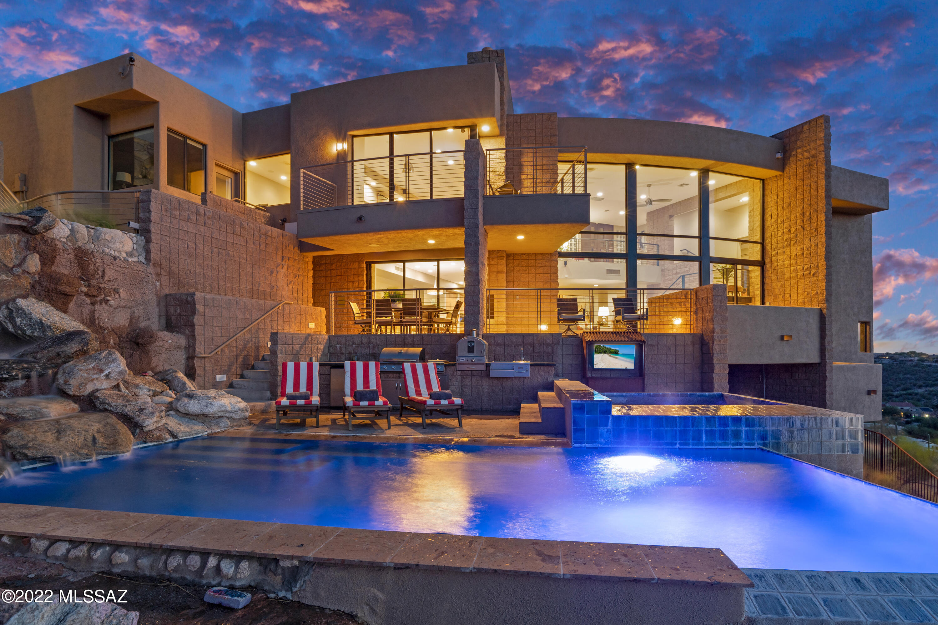 Stunning hilltop modern residence with 1 bedroom guesthouse captures sweeping panoramic views of the Catalina Mountains. With architecture by Kevin Howard, this timeless showpiece is sure to excite even the most discriminating buyer. 

Upper level features the well appointed primary suite with gas glass rock fireplace and floor to ceiling windows showcasing breathtaking late evening sunsets. Step out onto the private outdoor terrace overlooking the city and Catalina Mountain Vistas beyond. Primary bath features soaking tub with separate state of the art shower and oversized walk in closet. 

Main level features open living/dining layout perfectly situated for entertaining. Modern open kitchen includes top-end stainless appliances, custom cabine granite countertops, prep sink and a large picture window showcasing unobstructed views of the city lights. Main level accommodations also include 2 spacious guest bedrooms with captivating city and mountain views plus the guest bathroom. 

Inviting elements include both indoor and outdoor quiet sitting areas sequestered throughout the property, travertine flooring throughout, double-sided glass rock gas fireplace, generously sized game room, private office, private commercial grade elevator that accesses all three levels of the residence, several private terraces overlooking the infinity edge heated pool and spa, modern light fixtures and wired surround sound

Outdoor living space includes balcony overlooking the city that captures surreal sunrises and sunsets. Outdoor kitchen includes pizza oven, refrigerator, BBQ and access to the private guesthouse. 

Guesthouse with its own private entrance features 1 bedroom with modern en suite and living area with unmatched views that carry over from the main residence.  

This residence is a short drive to some of Tucson's most frequented  hiking trails, fine dining, resorts & spas and golf courses.