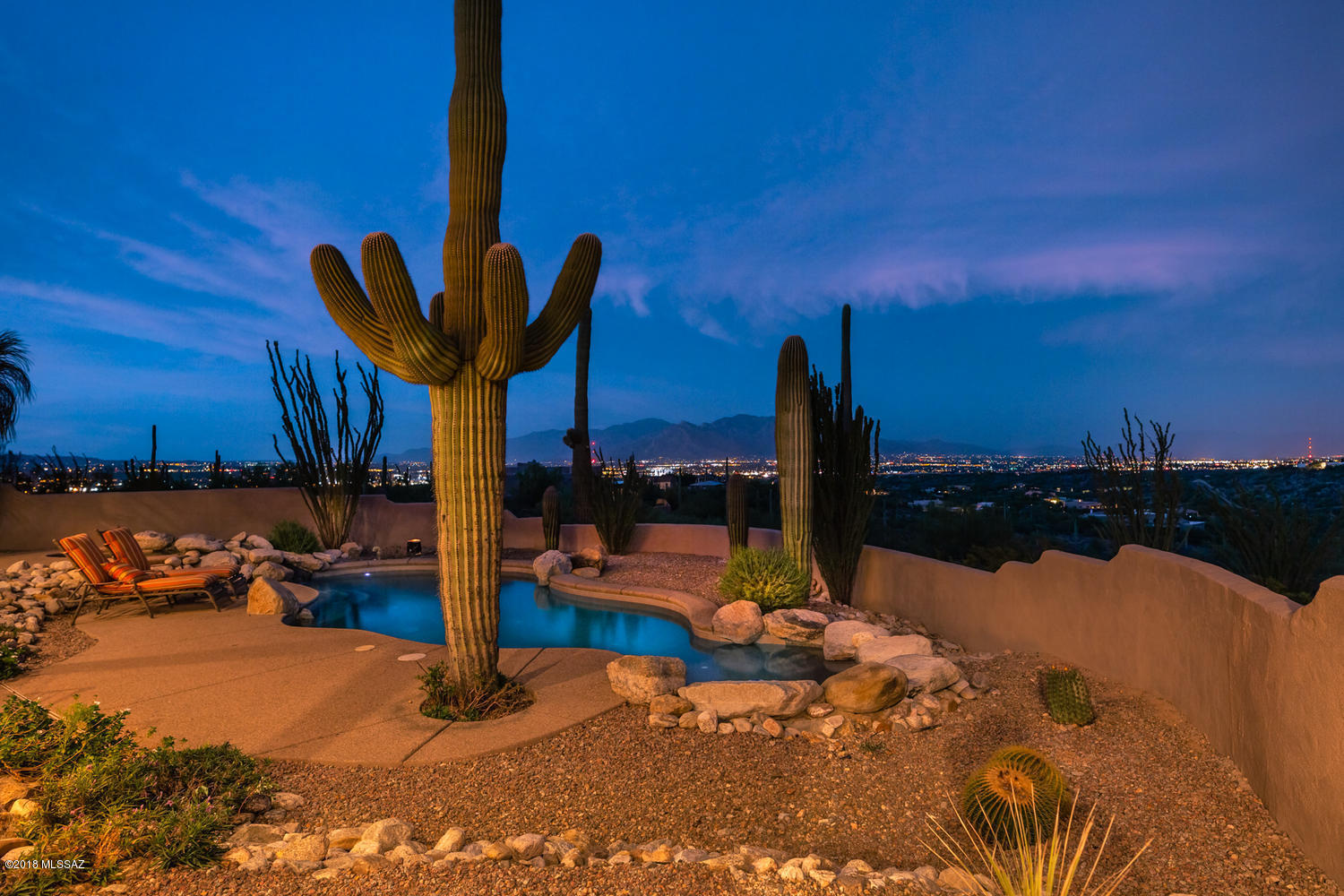 Engaging custom estate situated above Tucson Mountain Reserve with sweeping city and Mountain views and Saguaro National Park West as your neighbor. 2626 sq ft main house with alder wood cabinets and doors throughout,granite and stainless Kitchen overlooking floor to ceiling windows in great room. Wood beam ceilings, beautiful tile floors . 1192 SQ FT guest house with large master bedroom, den, 2 baths, approximately 623 sq ft climate controlled area in the attic of the guest house that could easily make a great game room or play room that is not included in sq ft. RV garage with full hook ups. Heated pool and spa. Abundant natural landscape surrounds this 3.34 acres, with 1172 sq ft of covered patios. Main house has a step down living room, guest house has no steps.