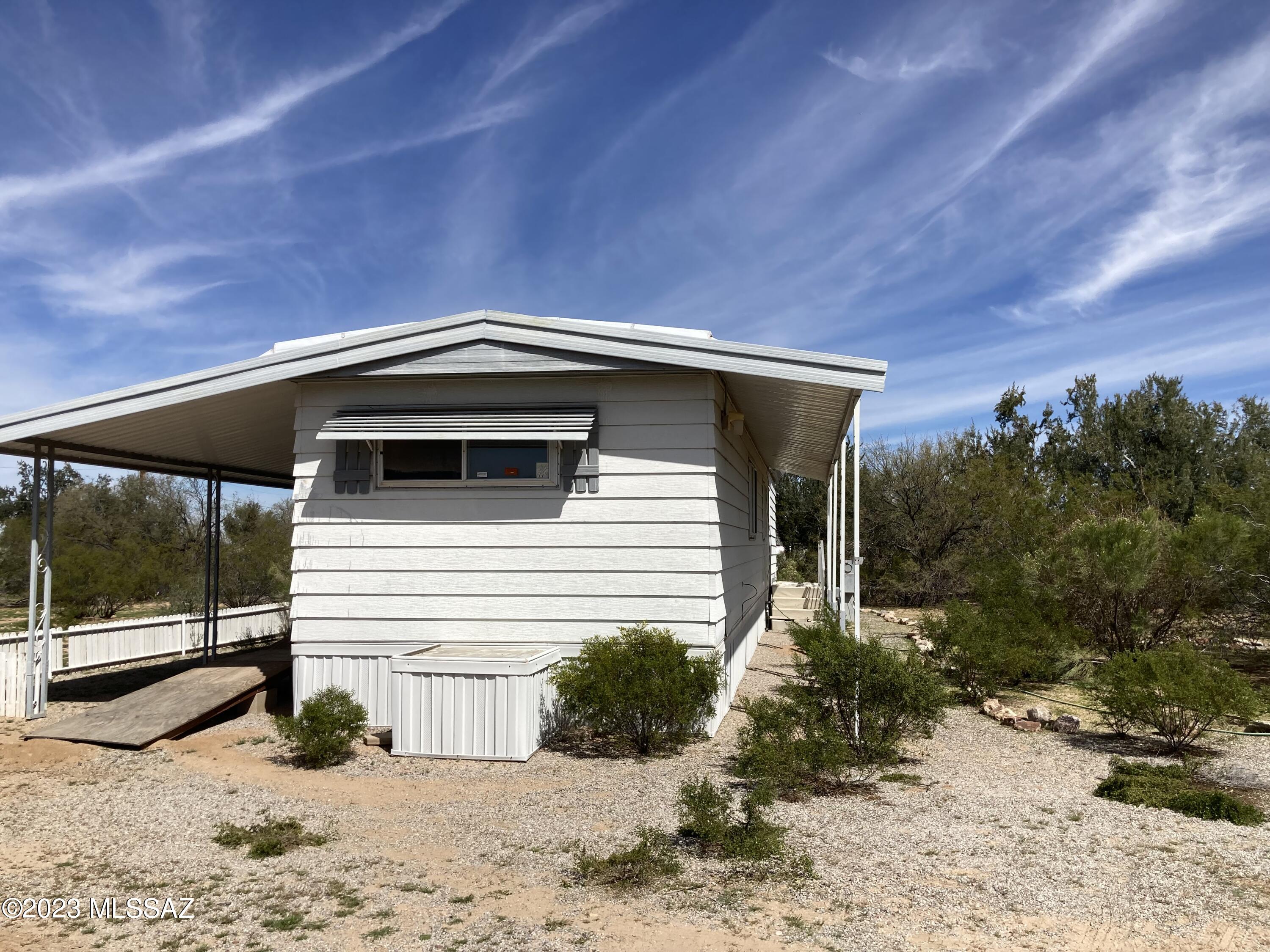 Older affixed mobile home on corner lot in Picture Rocks -More of a ''clean up'' than a ''fix up'' - Two Bedroom, One Bath with covered porch with ramp.  Large (660 sq ft) garage/shop/carport - Paved Road - convenient location