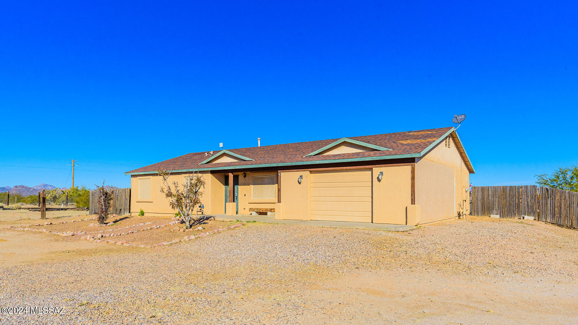 This property is in a great location. You can enjoy peace and quiet away from the city but still remain close to the freeway & other major amenities. This spacious, move in ready, single family home sits on a corner lot on just over an acre & has limitless possibilities. The fully enclosed, large backyard has wooden fencing & amazing mountain views. There is plenty of storage & the 2 car carport has recently been enclosed.  Enjoy friends & family around a fire-pit with the beautiful desert sunsets and clear, starry nights! Located just a few miles from Saguaro National Park and the Arizona-Sonoran Desert Museum.