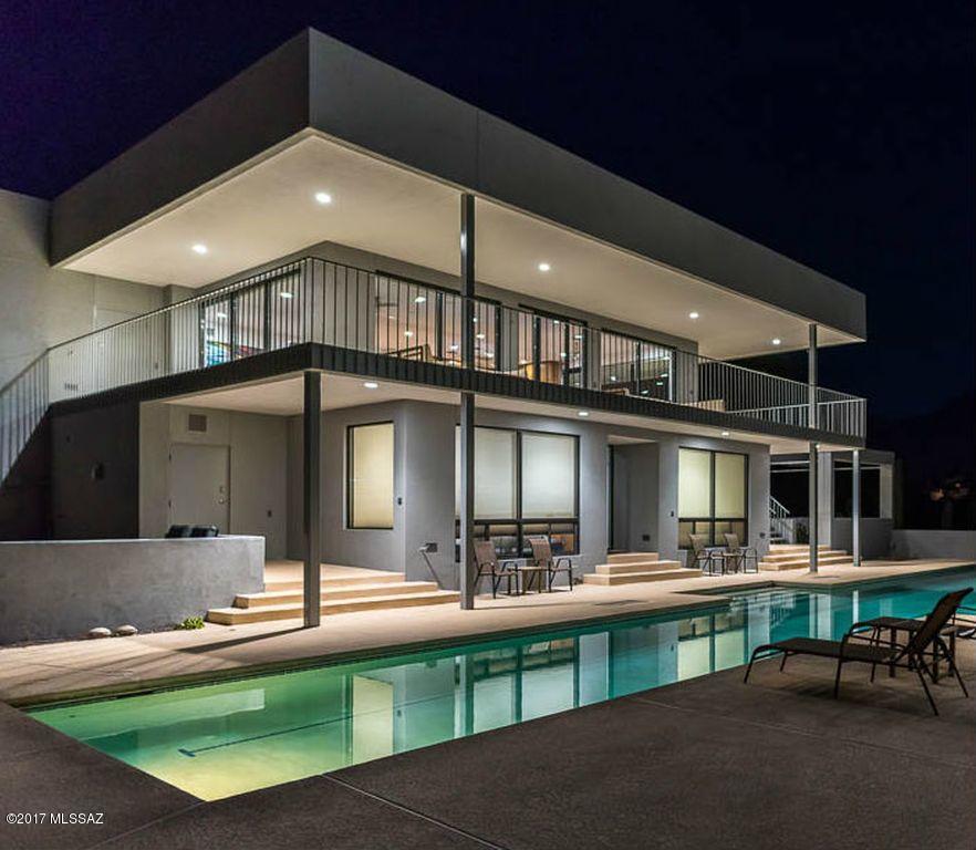 Feel like you're on top of the world in the modern architecture of the Skyline House.  The Catalina Foothills gem is sited on a ridge top to take in 360 degree views of the Catalina and Rincon Mountains by day and city lights by night.  
The property is a perfect balance of clean lines and minimalist forms that were highlighted in the recent updates.   The house features floor to ceiling dual pane windows, teak cabinets, granite counter-tops, sound systems, central vac, 75-foot solar heated lap pool, screened garden building, pool side cabana, citrus orchard, and more. The unique floor plan allows for private 2 bedroom guest quarters poolside with a second full kitchen/bar and separate entrance.  
House includes 4 bedrooms,3 baths, 2 kitchens, 2 laundries, and media room.