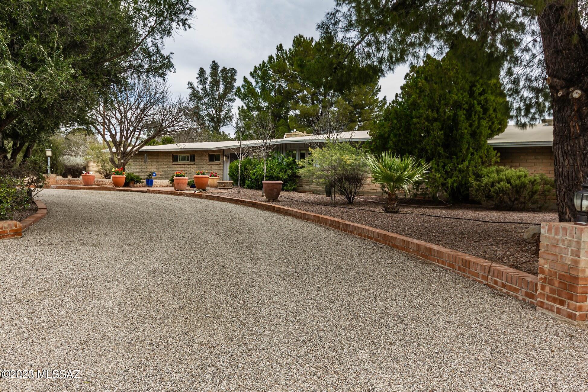 Beautiful ranch style home in gated Tucson Country Club Estates.  This 3 BR 4BA home offers just the right blend of  textures and accents, from rich wood to designer concrete flooring throughout.  The feel is total comfort from the moment you walk in.  Upgraded kitchen with natural stone counter tops, huge Sub-Zero refrig/freezer, Wolf dbl oven and cook top, large Island with seating, and custom cabinetry.  All bedrooms are complimented with walk in closets, bathrooms have been tastefully updated and the over-sized master bedroom features a private outdoor seating area. Additional amenities include a formal dining area, artisan fireplace, pantry and laundry area.  Beautiful back yard oasis with lush green grass and large covered patio. Includes a three-car garage with extra work shop.