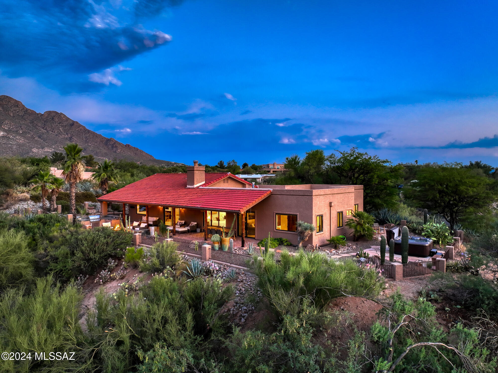 Seller to entertain/counter offers of $1.025m-$1.05m. Welcome to Desert Sky, where each day feels like a sunlit escape! This stunning home, perched on over an acre atop a ridge, offers sweeping views of the Oro Valley Country Club Golf Course, the majestic Pusch Ridge mountains, and Tucson's twinkling city lights. Situated in the desirable Oro Valley area, this property is your gateway to luxurious relaxation and the vibrant beauty of the Sonoran Desert—ideal for both outdoor adventurers and those seeking a peaceful retreat. Step into a spacious, 2,648 sqft single-story sanctuary, thoughtfully designed with turnkey, upscale furnishings (available on a separate Bill of Sale), and a bright, open layout that captures Arizona's natural light. Expansive picture windows frame every view, creating a serene connection to the breathtaking surroundings. Inside, sleek travertine floors, a cathedral wood-beam ceiling, and a cozy gas fireplace with tile surround add elegance and warmth.

The home's gourmet kitchen boasts a large island with breakfast bar and gas cooktop, quartz counters, stainless steel appliances, and a wine fridgeperfect for both casual meals and entertaining. A formal dining area adjoins this chef's space, ensuring a seamless flow for hosting. 

The expansive floor plan is highlighted by 3 spacious bedrooms, offering comfort and privacy for everyone. The first light-filled suite features an en-suite bathroom and showcases exquisite Mountain Views from the oversized sliding door to the back patio. The second suite is complete with a luxuriously designed en-suite bathroom with dual vanity and walk-in shower with dual shower heads. As you enter the French doors to the third bedroom, your eye will be immediately drawn to the expansive view from the sliding door overlooking the mountains and lush desert greenscape that surrounds the home.

Outside, the flagstone path leads to a private patio featuring a hot tub, while the rear patio is ideal for entertaining with a built-in fire pit and BBQ island. As the sun sets, Pusch Ridge illuminates in hues of gold and rose, offering a front-row seat to nature's nightly display from the comfort of your poolside oasis. 

Currently ranked in the Top 5% of homes by Airbnb, and one of the top grossing homes in all of Oro Valley, this property offers an exceptional vacation rental opportunity. 

Here, life unfolds gracefully, blending luxury with the timeless beauty of the desert. With no HOA, this home is a true reflection of upscale living in one of Arizona's most cherished communities, Oro Valley.