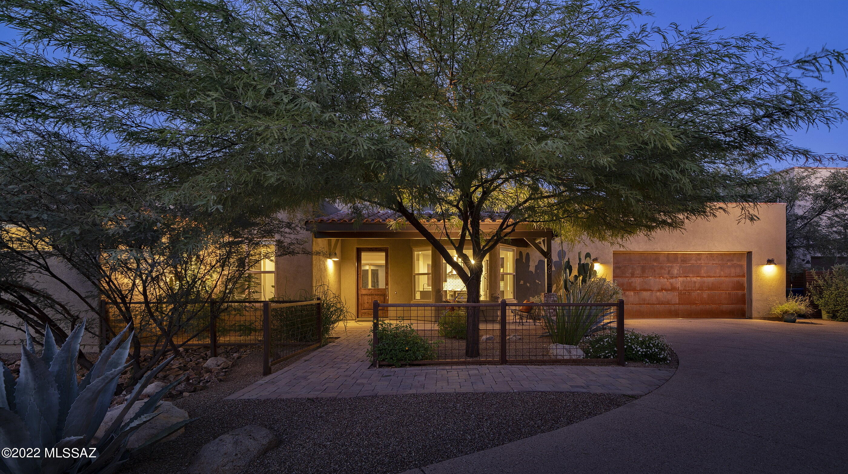 This stunning and updated residence, nestled within a privately gated enclave of 5 homes within the Historic Fort Lowell District, features a refined fit and finish level felt immediately upon entry. Beyond the home's lush courtyard approach and upon entry, the view extends into the great room giving the space a sense of lofty expansiveness. The interior aesthetic is complemented by soft modern tones and accents, with comfortable yet stylish interiors that provide the ideal backdrop for the individual design sensibility. The living, kitchen and dining rooms, being the primary activity points, flank the dedicated owner's suite and additional guest bedrooms, creating the perfect balance for both winter visitors, or full time residents alike. The kitchen features custom millwork, with striking wood tones, fitted with stainless steel appliances and warm granite countertops, that carefully choreograph the user's movement throughout the space. Exposed concrete floors line the interior, threading the living spaces together, providing continuity to the overall design. The floor plan, while open, features a split bedroom makeup, with the primary suite being privately sequestered on the North end of the residence, with the balance of 2 secondary suites situated on the South end. 

The sumptuous owner's suite, with sliding glass doors and view windows, allows soft natural light to spill into the space, while also providing access to the intimately-scaled outdoor veranda. Located just off the great room, the flex-room is easily utilized as a den, or home office/gym, while the secondary bedrooms (all ensuite) are spacious with generous closet storage and natural light. 

The East facing rear covered veranda is designed to extend square footage, allowing for covered outdoor seating, while overlooking a private Mesquite Bosque. Indoor and outdoor spaces are perfect for both entertaining or simply enjoying the surrounding natural desert landscape.