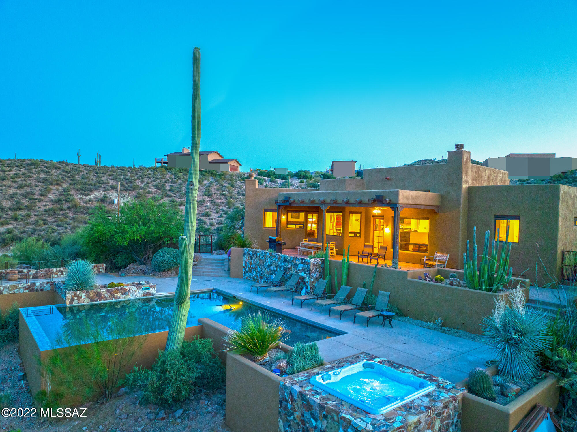 Is privacy your priority? Discover the world of peaceful living yet minutes from downtown Tucson. Amazing Santa Fe 3 bedroom, 2.5 bath home on private 5 acres abundant with local wildlife.  Magnificent panoramic views of surrounding mountains and city views. Kitchen w/abundant cabinets, stainless steel appliances and breakfast bar. Kitchen opens to separate dining area and great room w/vaulted ceiling and wood beams.  Split bedroom plan, primary bedroom w/wood burning fireplace, adjoining bath and wall in closet.  Enjoy the outdoor areas including brick paver patio overlooking mountains, Tucson Valley, city lights, negative edge pool, bubbly heated in ground spa. Energy efficient solar hot water system. Call now to view this unique property and upgrade your lifestyle.