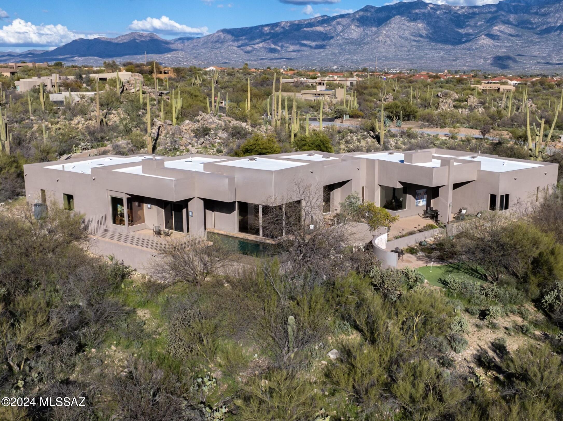 Experience the ultimate Arizona lifestyle in this stunning custom-built home in the exclusive guard-gated community of The Estates at Honey Bee Ridge. With 3 bedrooms, 3.5 bathrooms, a Den / Study, and an Office, this 5,365 SqFt contemporary-style home boasts luxurious appointments and breathtaking panoramic views of the Sonoran Desert's iconic saguaros and surrounding mountain ranges. The house is perfectly positioned on a 1.27-acre lot to maximize the stunning views, making it the perfect oasis for those seeking a premium living experience. As you make your way along the mature desert landscape and rock outcroppings you will be pleased by how secluded and private this property is, and you will be delighted by the cascading waterfall features that welcome you to this serene setting in the desert. No expense has been spared here, as this luxury home features an open split bedroom plan that is complimented by sharp edges, soaring ceilings, natural stone flooring, maple wood cabinets, and window walls that let in an abundance of natural light while capturing breathtaking panoramic views. Built for comfortable living and entertaining, the open concept allows for easy flow throughout the home. 

The open foyer welcomes you, while the grand Living Room is sure to captivate, as it boasts magnificent panoramic views from window walls that border the reflective negative edge pool. Adjacent to the Living Room is an Office with a built-in desk and shelves, and double glass doors that brighten the space and take advantage of the views. If you enjoy entertaining, the Formal Dining area with kitchen access will satisfy you, as it has a splendid east and west-facing view and offers the perfect space to celebrate special occasions with family and friends. The open Kitchen is a cook's delight, as it offers picturesque mountain views, and is appointed with 2 convection ovens, a large center island with a gas cooktop and sit-up bar for two, gorgeous granite countertops, and a casual dining nook that flows into the spacious Family Room. The designer gas fireplace is a focal point, along with window walls that provide sensational unobstructed views. 

Located in the North Wing of the home is a large Den / Study appointed with a double door entry, custom built-in wall cabinets that accommodate three TVs, and an en suite bath with walk-in shower. Adjacent to the Den is the Primary Suite which is a true retreat due to its extraordinary design, featuring window walls that border the negative edge pool, and provide access to the pool and private deck. An electric fireplace warms the space, while the corner window boasts majestic views from the sitting area that invites you to relax and enjoy some peace and tranquility. The en suite Bath is marvelous as well, as it offers a split plan with a wet bar/coffee bar w/ mini fridge, 2 vanities (one w/ makeup table), 2 wet rooms (one w/ bidet), 2 custom walk-in closets (one w/ Sauna and the other w/three-way mirror), a jetted tub, and a large central walk-in shower with bench seat and dual shower heads. The en suite bath also includes an Exercise / Meditation Room that has stunning east-facing views and direct access to the driveway. 

Bedroom 2 and Bedroom 3 are located in the South Wing, which shares a large walk-in shower with bench seats and dual shower heads. Bedroom 2 features a double sliding door closet and an en suite vanity, while Bedroom 3 offers an ensuite vanity with a makeup table, a large custom walk-in closet, and a double door entry. The Laundry Room has built-in upper and lower cabinets, and a utility sink, and houses a front-load washer and dryer with a pedestal.

Whether you are entertaining or relaxing you will thoroughly enjoy the expansive rear courtyard that offers a spacious covered area for outdoor dining, a built-in BBQ, and a fire pit. The rear courtyard also provides access to the reflective negative edge pool with private patio space for sunning. If you prefer to work on your short game or have some friendly competition, you will enjoy the backyard putting green that borders a sizable flagstone patio with bench seating and a custom mural. 



This stunning home offers timeless architecture and captures the Sonoran Desert's beauty with its Remarkable Panoramic Views, Spectacular Sunsets, and Starry Skies!
