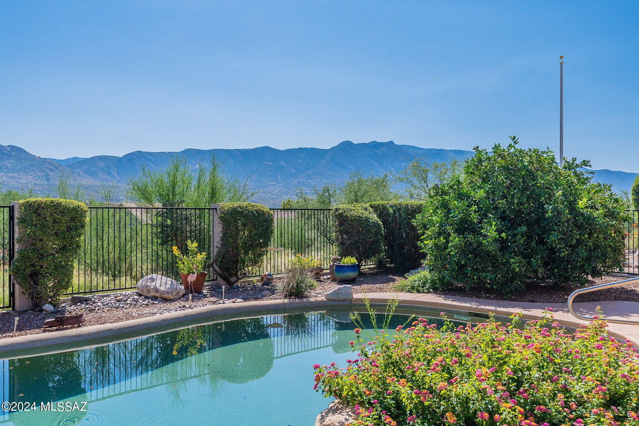 Welcome to this beautiful TOPAZ Spanish Hacienda accented home. From the moment you enter, you'll feel the warmth of the Southwestern colors and ceramic tile flooring. The stained glass inlaid wrought iron gate opens to a living space perfect for dining, games, or relaxing by the fireplace. This home boasts three master suites and a den with a murphy bed and powder room, which can serve as a fourth bedroom. Hacienda-style shutters complete the Southwestern charm. Enjoy unobstructed views of the Catalina Mountains from nearly every room, your patio, or while soaking in the pebble tech-lined pool. If you desire a Southwestern/Spanish Hacienda style home, this is it!