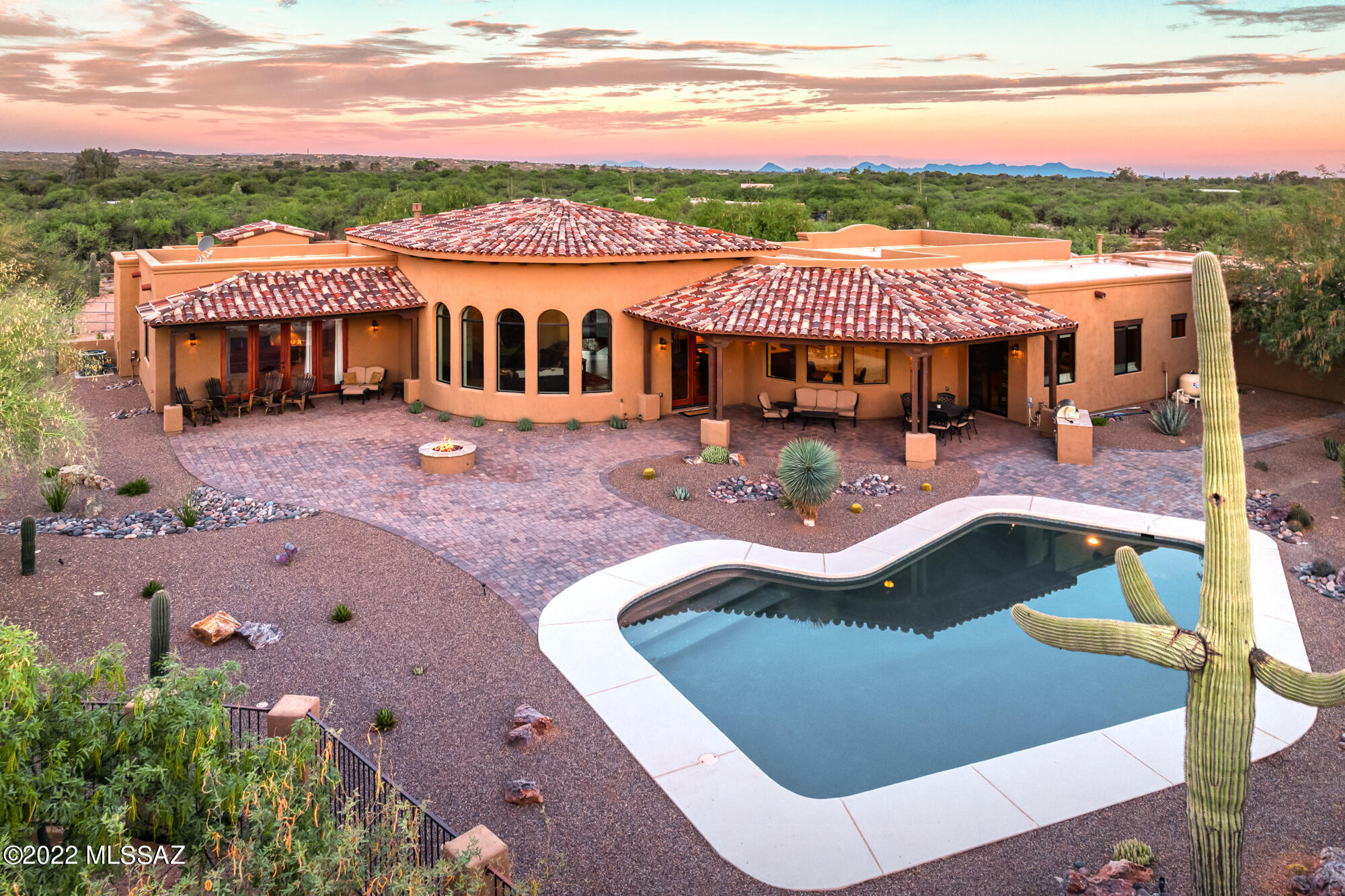 For those looking to experience the epitome of desert decadence, look no further. Privately situated in the prestigious La Cebadilla Estates, this masterfully rebuilt home showcases unrivaled panoramic mountain views from the inside out. This flawlessly executed home was fully rebuilt in 2018 and provides elevated desert living through extensive modern amenities and upgrades. Situated on over 3 acres of horse property with a 4-stall barn and arena, with trails directly from the property that lead to miles of serene riding vistas!!  Upon entry, find yourself greeted by the exquisite living room boasting high ceilings, elegant fireplace, and views so big they bring the outside in. Gourmet expansive kitchen features granite counters, huge island, breakfast bar, wine fridge, beautiful warm alder wood  cabinetry, top-of-the-line Stainless Steel Monogram appliances, and walk-in pantry a breakfast nook surrounded by windows. Two large master suites; one boast with a wall of windows showcasing the majestic vistas of the Rincon Mountains with a different viewpoint typically seen by others. Luxury ensuite bath boasts split vanity, spacious luxury shower, and huge walk-in closet. The second spacious second master suite delivers luxury ensuite bath with dual vanities, huge shower, and large walk-in closet. Guest Quarters complete with a private bedroom, living room, a luxury kitchen with granite counters, bathroom, and a lovely outdoor patio. Exceptional outdoor living space boasts covered wraparound patio with BBQ, outdoor dining area, glass firepit and exquisite pool with an unobstructed view of the sweeping Rincon Mountains. Nicely appointed living room with sink. Additional interior features include a private office/den with fabulous built-in bookcases, and wood beam accents in the private dining room, gorgeous warm tile plank flooring, and a view from every window.