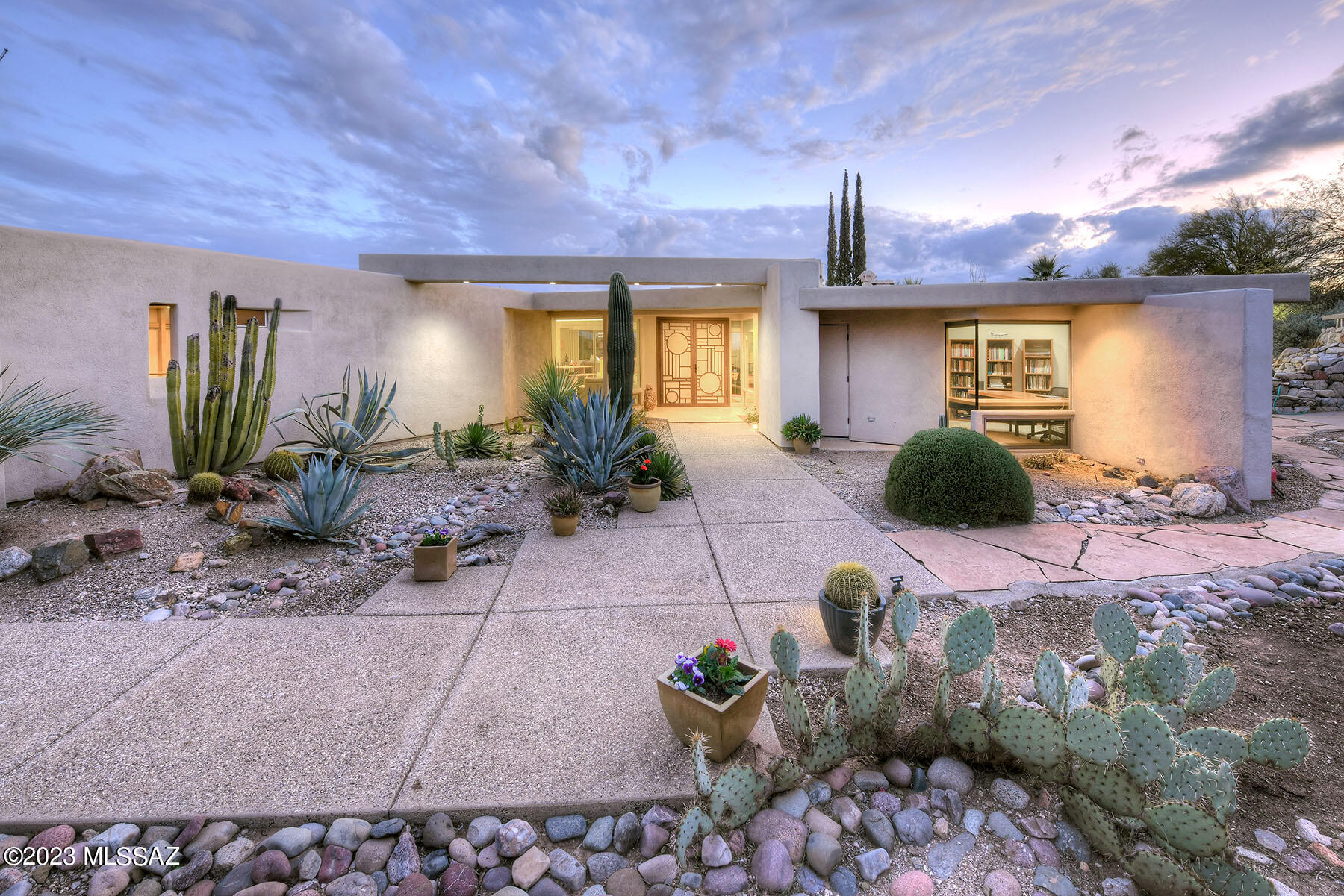 Beautiful Catalina Mountain vistas & expansive City views bookend this Mid-Century Modern masterpiece tucked in a garden oasis. As you stroll through he gated front yard the one-of-a-kind character of this house is apparent. The path to the front door yields to the refinement of travertine tile, solid maple flooring & floor to ceiling windows w/an amazing indoor/outdoor fireplace. Kitchen, living areas & gorgeous Bkyd flow together for an expansive, open view. Island Kitchen features underlit hard wood cabinets, & includes appliances from Sub-Zero, Thermador, & Dacor. Primary BR is a private sanctuary w/ patio access, dual vanities, separate new deep-soaking tub, & WIC. Another wing of the home houses 2 Guestrooms, Large guest BA, & stunning office/4th BR. Backyd w/City views, pool, waterfall, outdoor grill & lovely Hot Tub. Retractable screen on back patio allows for additional shade. A delightful surprise on the West side of the home is a detached, earth insulated structure for use as a Studio, Workshop, or Kids Playhouse. A truly unique home with amazing architectural lines, a superior location just a quick stroll to the wonderful Neighborhood Recreation Center with Pool, Tennis Courts and Party Ramada.