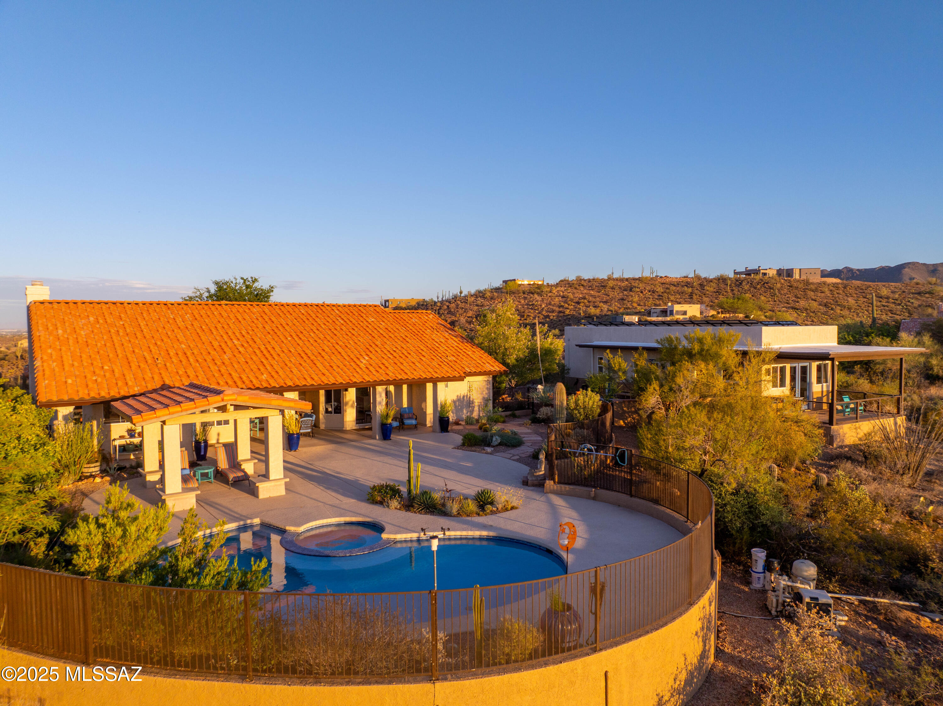 A Botanical Refuge in the Foothills of the Tucson Mountains. Welcome to a one-of-a-kind desert sanctuary where luxury meets ecological harmony. Nestled in the foothills of the Tucson Mountains and perched above the protected Sweetwater Preserve, this custom-designed estate offers 360-degree unobstructed views, more than $430,000 in curated upgrades, and a lifestyle defined by natural beauty, sustainability, and tranquility. Crafted with intention and elegance, the main residence features premium finishes, floor-to-ceiling glass that captures sweeping desert and mountain vistas, and seamless indoor-outdoor living that blurs the line between home and habitat. Each sunrise and sunset becomes a private spectacle from nearly every room.  Next, step into the expansive outdoor retreat with an oversized patio leading to a resort-style heated pool and spa with upgraded shell-bit plaster. Prepare for endless nights of entertaining or secluded nights full of relaxation while overlooking the desert skies and allowing the desert landscape to become your personal canvas. Currently being utilized as an Art studio the 1,000 sq ft guest house offers a private 1 bed, 1 bath residence complete with its own patioperfect for guests, extended family, or luxury rental potential. Tucked between the main residence and guest house is a thoughtfully designed courtyard, centered around a sustainable graywater system that collects runoff from the guest house to nourish nearby treesan elegant and efficient solution that reduces irrigation needs while supporting a thriving desert ecosystem.The surrounding landscape has been carefully shaped into a refuge of restoration for both people and wildlife. When the studio was constructed in 2018, every cactus within the building footprintincluding numerous young saguaroswas meticulously hand-dug and transplanted to other areas of the property. One such saguaro now stands proudly on the pool deck, a living symbol of the home's commitment to stewardship and renewal.Today, the yard has evolved into a vibrant desert habitat, alive with the movement of native birds, butterflies, bees, and pollinatorsoffering a rare blend of ecological integrity and personal sanctuary.This is much more than just a homeit's a living sanctuary where luxury and sustainability live in harmony, where every sunrise brings inspiration, and every sunset whispers peace. It was thoughtfully designed, meticulously maintained, and deeply connected to the land it rests on. This is a very rare opportunity to own a property so unique, so please take the time to schedule your private tour today, because tomorrow will be too late.