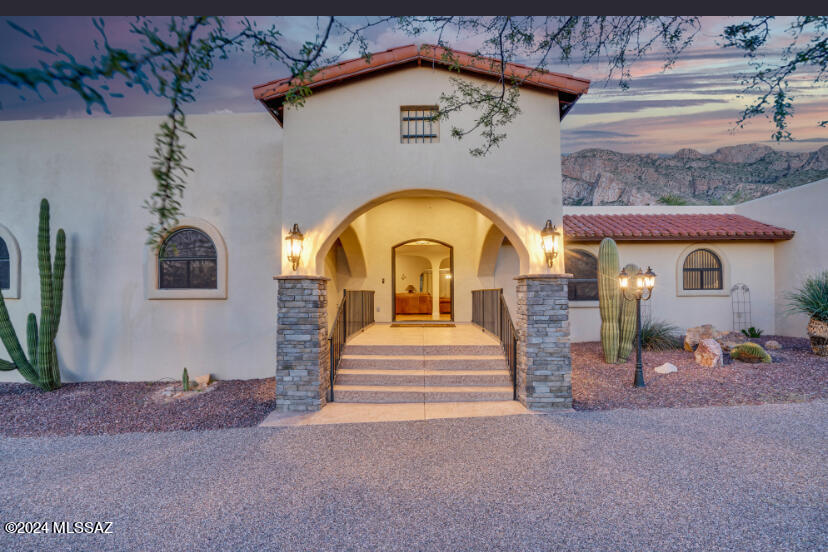 Experience unparalleled comfort & stunning mountain views in this unique, multi-family 4-bedroom, 5-bath home set on a full-acre lot at the base of Pusch Ridge. Layout features large living space open to kitchen as well as eat-in kitchen. Relax in your entertainment area that offers versatile bar with counter seating, sink, tap, and mini-fridge. 
Gourmet kitchen includes stainless steel appliances, granite countertops, island, wall oven, under-cabinet lighting, convection/microwave and RO. In addition, enjoy the versatility of a formal dining room, 2 bonus rooms that could serve as man-cave, office, craft area, & separate guest quarters w/full kitchen, private entrance. 
Relax in your primary suite with cozy bee-hive fireplace, oversized walk-in closet, luxurious bathroom w/jacuzzi-style tub and separate shower. Layout accommodates direct access to the patio/pool areas as well as nearby roof-top balcony.
Your backyard Oasis awaits -- Ideal for entertaining. Resort-like exterior w/sparkling Pebble-Tech pool features lots of patio area, lighted walkways, Orchard, built-in BBQ & fountain.
A fully gated private yard area allows plenty of parking alongside a 3 car detached garage w/restroom, AC, & workshop. The south side of the home offers another 2 car attached garage. 400 amp electrical service to home. Two gates, one automatic, add to the security of the fenced formal yard areas.
Enjoy nearby trails, hiking, birding, and all the amenities of Oro Valley, AZ.