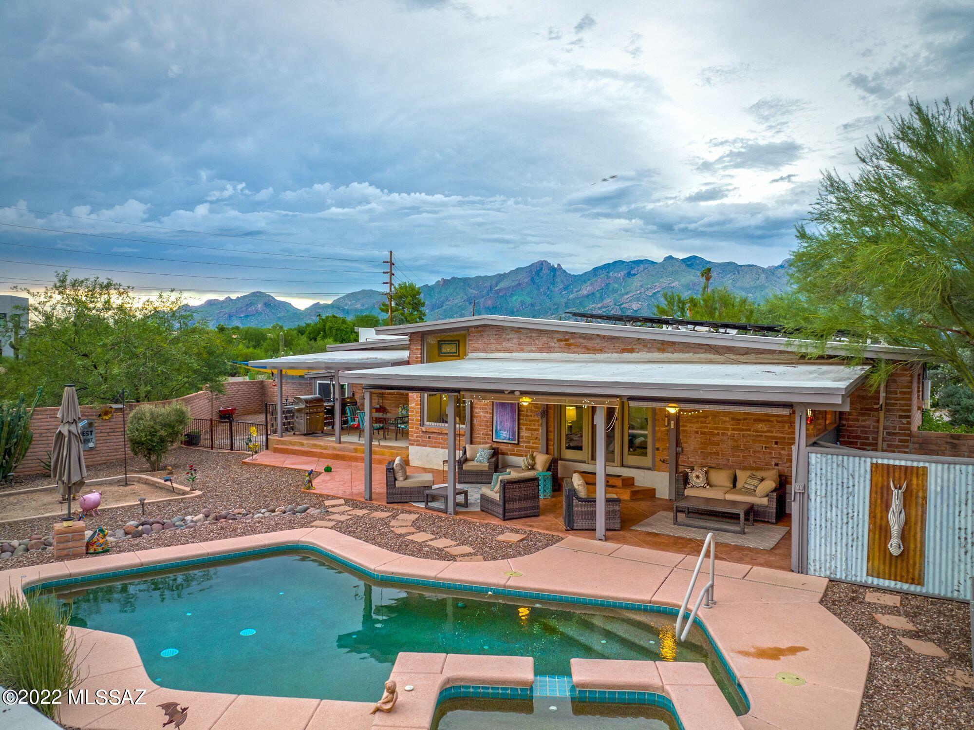 Serene desert oasis in the Foothills on over 1.5 acres of zoned horse property. Catch views from the Catalina's all the way to downtown from this architectural masterpiece that has been completely redesigned with all of the modern amenities and style that one could desire. This home has overseen extensive renovations and updates that were completed in 2019 including complete redesign of the living areas and kitchen. Custom cabinetry, quartz countertops with custom recycled glass and concrete island, wine bar, high-end appliances including induction cooktop and convection oven, redesigned workspace off kitchen, and an oversized laundry room are just a few of the updates that the home has overseen. All new terrazzo printed tile and restored stained concrete throughout the home (no carpet). Enjoy the energy efficiency and low bills with all new windows throughout and an OWNED solar system. The backyard offers privacy of the Sonoran desert as well as gorgeous sunsets and city views that you can take in from multiple covered patios or the pool/spa. The large temperature controlled workshop and oversized garage offer plenty of creative workspace. The lot continues to the NE with a large circular driveway and space to add more to this amazing property. Welcome home!
