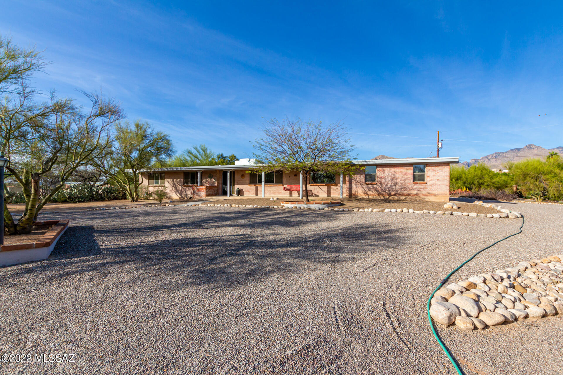 Beautifully remodeled classic brick home located in the desirable Casas Adobes Los Arboles subdivision! Nestled on close to an acre lot, this updated mid-century home is situated in a quiet cul-de-sac with picturesque mountain views. Enjoy the private backyard oasis with newly plastered pool in 2022 and mature orange/lemon trees. The fully block walled backyard offers a well-kept lawn and full-length North facing back porch for year-round enjoyment! The thoughtfully remodeled kitchen boasts quartz countertops, maple cabinetry, SS appliances, center island, and a lovely breakfast nook overlooking the resort-style backyard. Master bedroom features walk in closet, plush new carpet, and access to the backyard. Remodeled ensuite bath complete with executive height dual vanity, quartz countertop maple cabinetry, and stylish tiled shower. Enter the inviting family room to find gorgeous exposed beams, a classic mid-century brick fireplace, sleek porcelain tile floors, and easy backyard access. Spacious 2-car garage with newer 18-foot-wide garage door/quiet closer. Workshop and ample storage off garage. The expansive lot offers parking fit for all your toys! Ideal proximity to exciting shopping and dining options. This home will not last long. Come enjoy it for yourself!