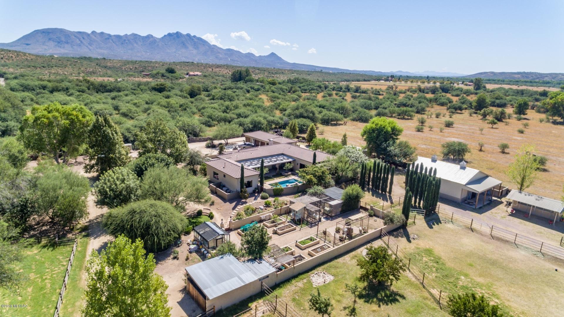 This custom ranchette is nestled in the lush Santa Cruz River Valley adjoining one of the largest natural Cottonwood/Willow forests in the world and is situated near the thriving Historic and Artisan community of Tubac, Az.  Enjoy  a country lifestyle as well as the peace and quiet this lovely Hacienda provides yet only minutes from Interstate 19 with easy access to Nogales and Tucson.  The moment you drive through the gated entry you feel the tranquility this lovely home and grounds provide.  This home has approximately 3533 square feet of living space which includes 3 bedrooms and 4 baths as well as a den/office area. The home has an attached guest casita as well as a two car garage. The property also features an orchard, several indoor and outdoor fireplaces, a horse barn including 3 stalls, a tack room, an air conditioned kitchen/lunch room as well as a wash rack.  The property also has a chicken coop and a  small greenhouse for plants and vegetables. This is a perfect opportunity to enjoy a blended rural lifestyle yet with close proximity to shops, restaurants and all that Tubac and Southern Arizona have to offer.