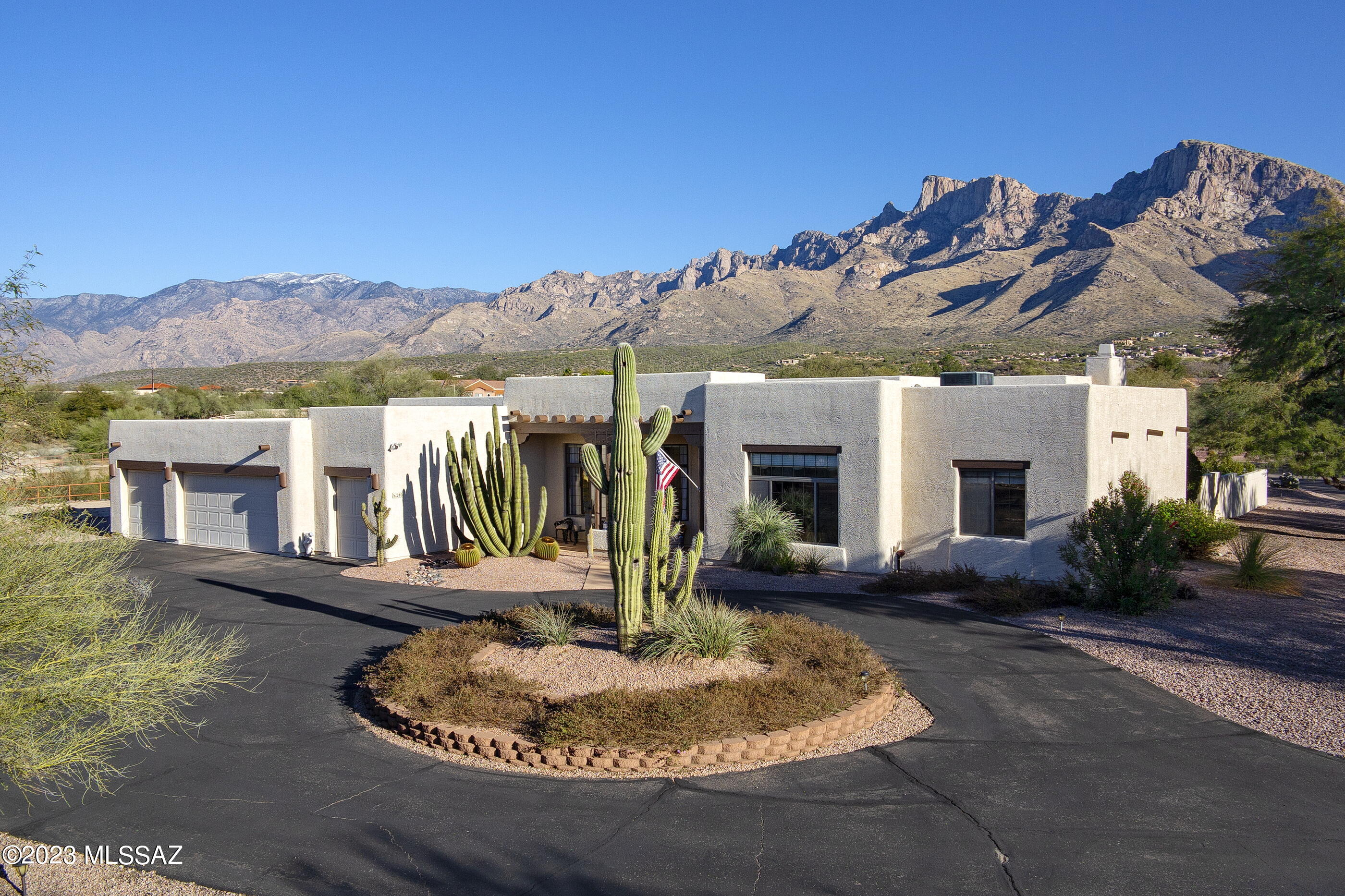 Panoramic Catalina Mountain views from this 3333 square foot home in the coveted Oro Valley Country Club! This home has a split-bedroom floorplan, open living space and option to create a fourth bedroom if desired.  Mountain views are showcased through the windows in the great room, which is complete with gas fireplace and wet bar.  Large open kitchen has it all—an abundance of cabinetry, granite counters, Fisher & Paykel 6 burner gas cooktop, KitchenAid double convection ovens and Sub-Zero paneled fridge.  Meal prep is a breeze on the oversized island with two Sub-Zero crisper drawers and dedicated prep sink.  The kitchen also offers seating for six at the breakfast bar, a pantry, wine fridge, a convenient built-in desk and adjacent casual dining area. An additional formal dining area i off the foyer. 
 The primary suite also has dazzling mountain views, and access to a private covered patio. remodeled bathroom with zero threshold shower, separate vanities topped with quartz (one with countertop "garage" for easy access to styling tools or frequently used items) and dual walk-in closets with built-ins. The laundry room is conveniently located nearby. 
The guest wing of the house is comprised of two guest bedrooms, a full guest bath, an additional half-bath and a large room currently utilized as a den (but could be modified into a fourth bedroom). The larger of the two guest bedrooms (currently a craft room) is tiled and offers a pull-down bed and a peek at the Catalinas. 
Car aficionados, golf cart owners or holiday décor enthusiasts will love the four car garage. While the exterior of the home is a Southwest-style, the interior has contemporary bones and could certainly be modified to suit the tastes of the new owner. 
The large, fenced portion of the property offers faux grass, huge mature citrus trees and stellar views. The oversized covered brick patio spills out to a sunny area with a firepit and gas BBQ.  An elevated planter hosts roses and other plantings along the back wall.   Beautiful 1.1 acre lot is flush with possibilityone could expand out from the back wall and add a pool or other amenities, if desired.  

Perched along the banks of the Canada del Oro near the base of Pusch Ridge, this exclusive golf course community that preceded the Town of Oro Valley is not only historically relevant, it is one of the most wildly beautiful and coveted communities in the area. Featuring a gorgeous private golf course resplendent with mature trees, this gorgeous community offers rolling streets with jaw-dropping views. Thoughtfully oriented large lots allow residents to be as social or as private as the prefer. The private golf course offers full and social membershipsbut there are no requirements to join to be a resident here.
With an excellent location and easy access to Oracle Road as well as the popular 131-mile multi-use "Loop", getting around is a breeze. Your new home is located mere moments to the soon to be reimagined and rebranded Oro Valley Village Center (complete with shopping, dining, and movie theaters), the Oro Valley Library, Catalina State Park, Town Hall, The Oro Valley Farmers Market at Steam Pump Village, and an array of different shopping and dining options.