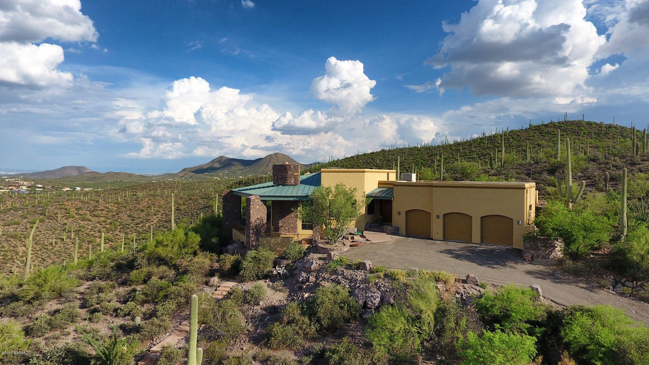 Dramatic one owner home sitting atop 18+ acres in the highly sought after Tucson Mtns.  Every room boasts amazing mountain and city views.  Stones collected off property have been used to create pillars surrounding home, along with an inside floor to ceiling fireplace.  Open concept allows outdoor to come inside and every room has a natural feel with the mountain.  Completely covered veranda winds around the home, creating another outdoor living area featuring outdoor BBQ, pool and spa, and outdoor fireplace.  The sky is truly the limit in this luxury home oozing in comfort.  Close to shopping, only 15 minutes from downtown attractions, U of A and fabulous dining.  A true treasure at the top of the mountain.