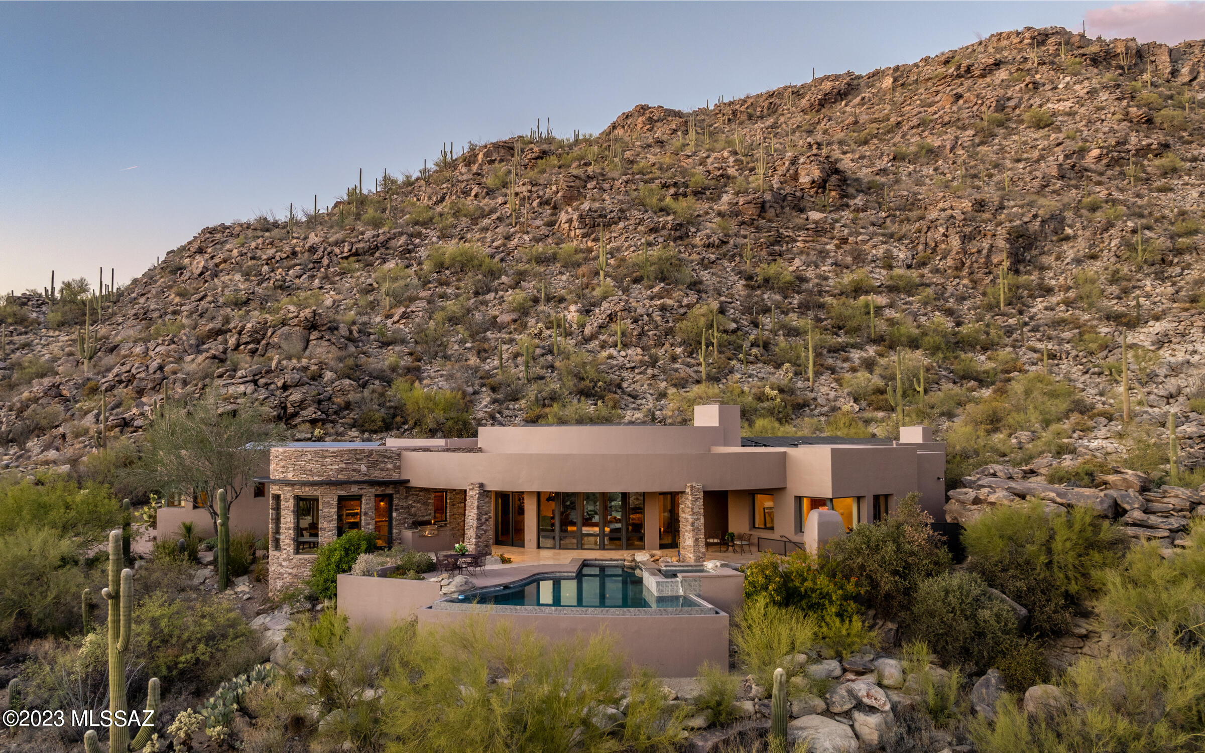 Luxury living awaits you w/mesmerizing city light and endless mountain views.  Nestled in the hillside rock outcroppings of guard gated Canyon Pass at Dove Mountain, this Ron Robinette designed home is drenched with magnficent views from basically every room in the home. Ron's renowned recessed ceilings w/accent lighting is a plethora of rooms - what a spectacular and relaxing setting in the evenings, dusk & dawn. Quality block construction.masonry walls - soft curves graciously invite from room to room. Beautiful stoned wall interior/exterior entry. Many rooms w/quiet power shades.  Highly desired south facing backyard viewing of city lights. Endless is the true word to describe the abundant storage in this home - even the garage -most all w/air conditioning. A truly quality custom home.