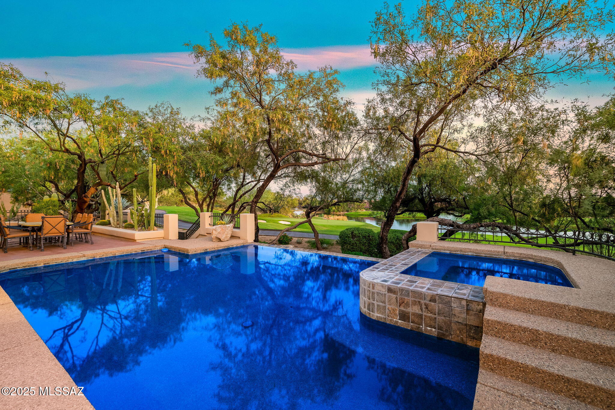 Enter a world of striking architecture, refined comfort & rustic elegance in this exquisite residence tucked within the gated community of Ventana Canyon Estates. Inside, a dramatic great room welcomes you with soaring 16-foot ceilings, stately wood beams, a grand wrought iron chandelier, travertine flooring & expansive windows that flood the space with natural light. Whether you're hosting an elegant dinner in the formal dining area or enjoying a casual breakfast in the cozy nook, every meal is framed by stunning views & timeless design. Blending indoor sophistication with outdoor serenity, the home's seamless connection to nature offers panoramic views of the 4th green and the shimmering lake beyond—an idyllic setting for al fresco dining, sunset cocktails, or a refreshing swim in the negative-edge pool. With direct golf course access, recreation is quite literally at your doorstep. The spacious downstairs primary suite is a private sanctuary, featuring vaulted tongue-and-groove ceilings, a cozy fireplace & a spa-inspired ensuite bathcreating a retreat of pure indulgence. Each of the four additional bedrooms offers its own private escape, complete with luxurious finishes, ensuite baths & private balconies. Come experience the uncompromising quality, timeless style & lifestyle privileges this extraordinary home has to offer.