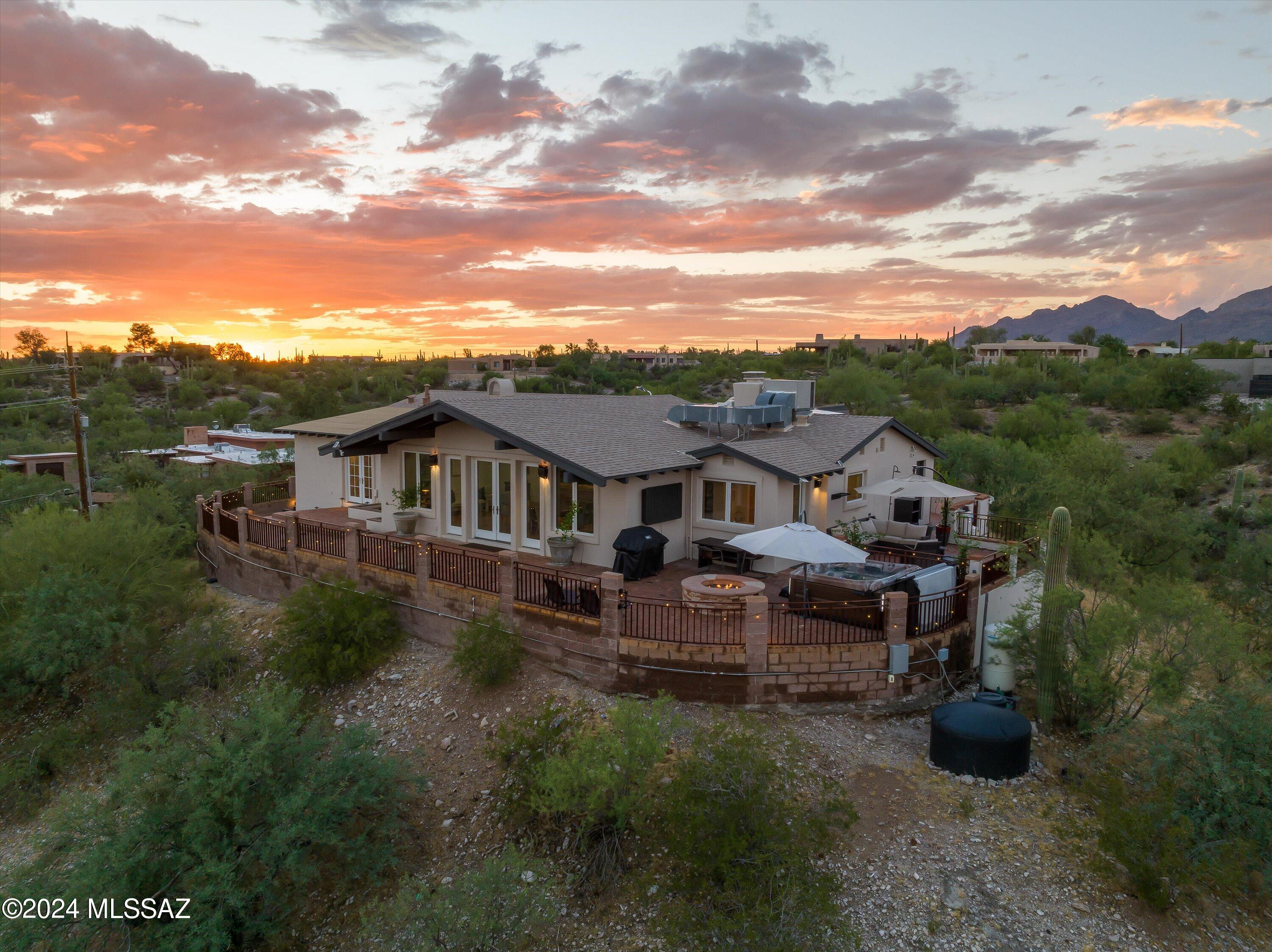 Don't let the address fool you!  This is a must-see Catalina Foothills home with stunning panoramic views!  Discover this beautiful hilltop home offering immense privacy, 360-degree views, and tasteful architecture. Spanning over 4,000 SF, this property includes a 3-bed, 3-bath main home, an attached Next Gen guest suite, and 600 SF detached recording studio/office/gym, great for a home-based business or hobbies.

Home is situated atop a 2.74-acre saguaro-studded elevated lot which provides extreme privacy, no HOA, a private well, and desirable SR zoning. Enjoy breathtaking views of the mountains, city lights, sunrise, and sunset, all while being conveniently located in the foothills just north of River Road. Inside you'll find generous-sized bedrooms, massive dining room, walk-in closets, vaulted ceilings, fireplaces and large Pella windows and glass doors showcasing the stunning views.  The chef's kitchen features a gas range, indoor grill, subzero fridge and granite countertops.  The bathrooms are spacious and luxurious, featuring walk in showers and spa-sized garden tubs.  The closets and pantry are large and have custom built-in shelving to help keep you organized.   

Step outside and enjoy the view with the expansive wrap-around patios where you will enjoy telling stories around the gas firepit, grilling as the stars come out, or watching those stars and city lights from the hot tub. This home is perfect for entertaining with plenty of indoor and outdoor space, including the guest house and recording studio for those guests that won't leave!

The detached Recording Studio is heated and cooled with new mini splits and can satisfy the noisiest of musicians, as designed.  Not musically inclined? No problem!  This space is great for your home-based business where you can take clients safely without getting them too close to home or sit and work in peace away from the noise of a happy home.   Other uses would be a killer home gym, workshop or he/she shed that will make even the Joneses jealous.