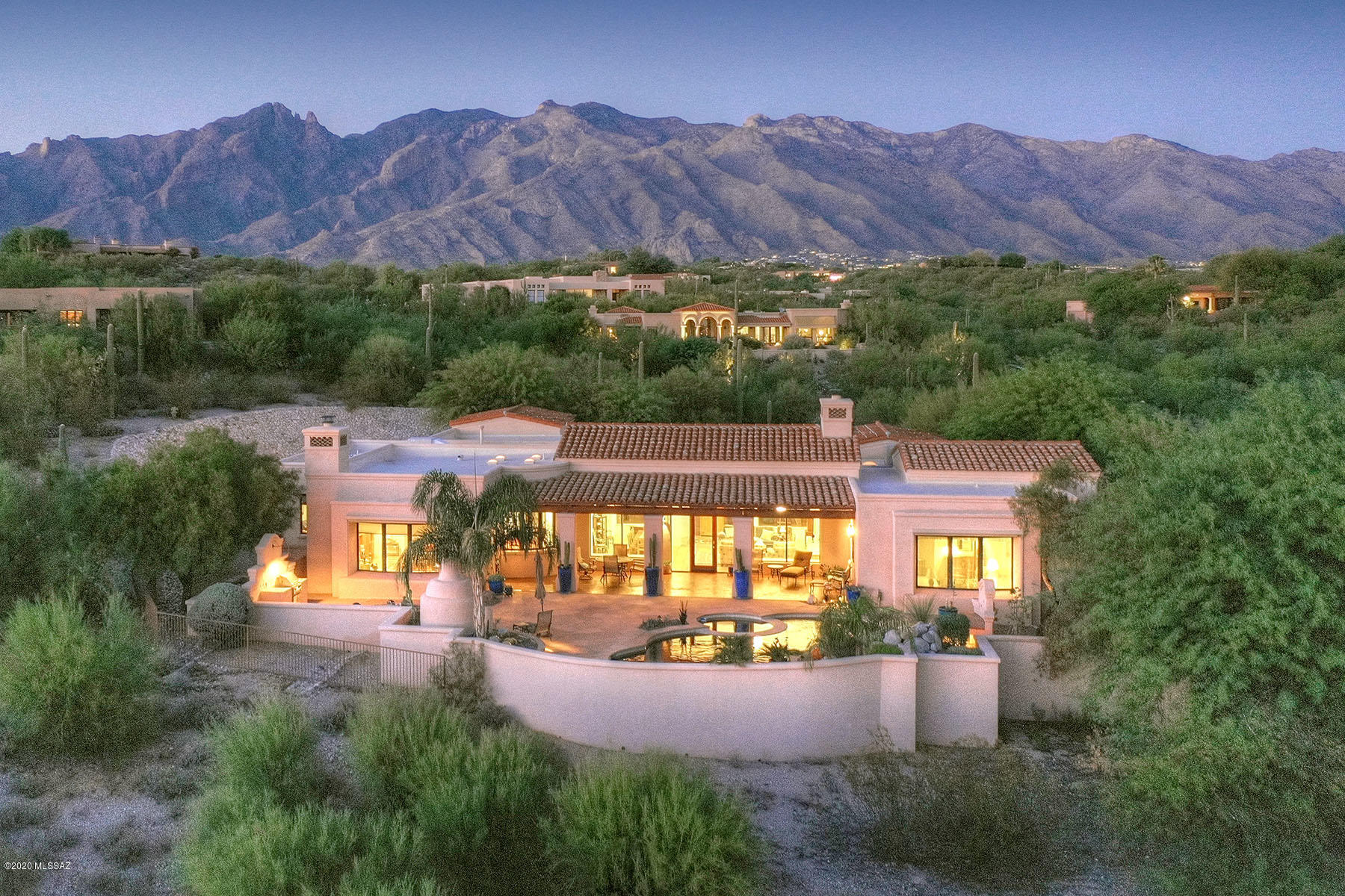 Beautiful Cat Foothills 10, Kevin Howard exquisitely designed Spanish Mission 4556 sqft Masonry home. Perfectly sited on a corner lot w/City lights & forever Mt.Views. Enter thru charming courtyard into elegant living room/dining area w/FP & dramatic 17' wood beamed Cathedral ceilings. Pella windows/drs, sep kitchen-greatroom w/FP, new SS Kitchenaide range, doubleoven & dishwasher. 4 bdrm, split floor plan, 4th bedrm is office w/its own entrance. Cherry cabinetry thruout. Recent upgrades incl. whole house evaporative coolers, instant hot H20, UV Air Purifiers, built-in bookcases, Sunscreens, Security Screen doors, repainted interior, new carpet, Patio mister system, Auto lighting & more! Stunning xeriscaped backyard w/pool, spa, FP,BBQ, separate fenced yd. XL 3 car garage.